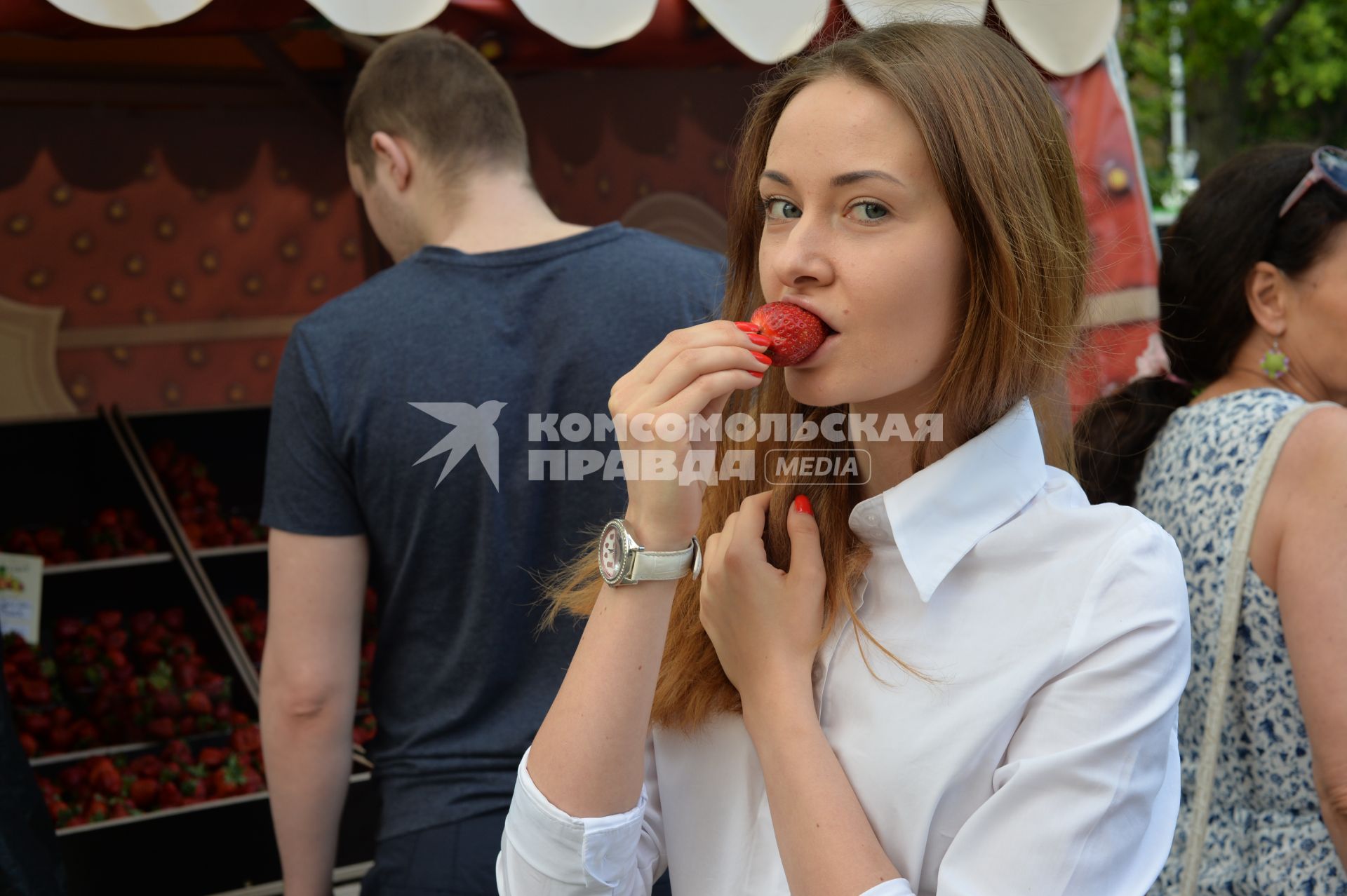 Москва.   Девушка ест клубнику.