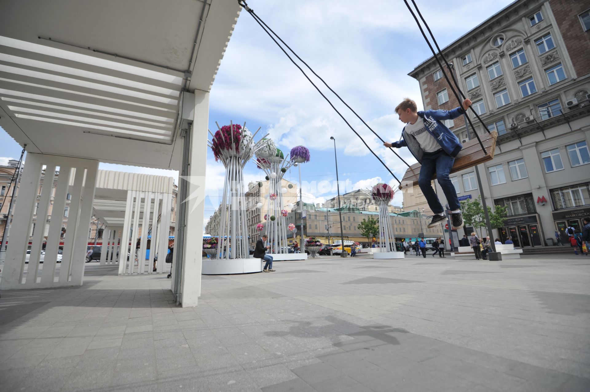 Москва. Мальчик качается на качелях на Триумфальной площади.