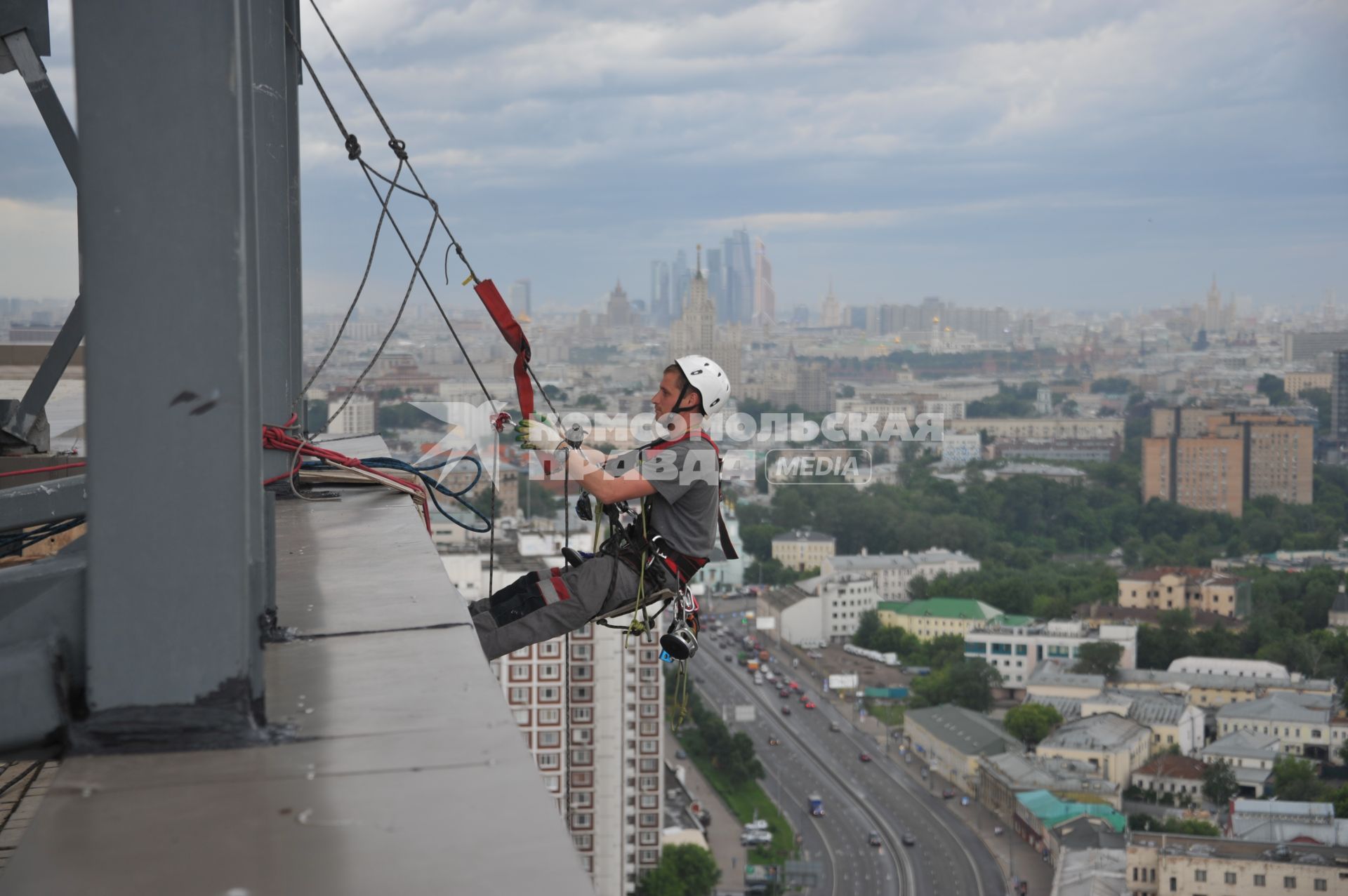 Москва.  Промышленный альпинист во время работы.