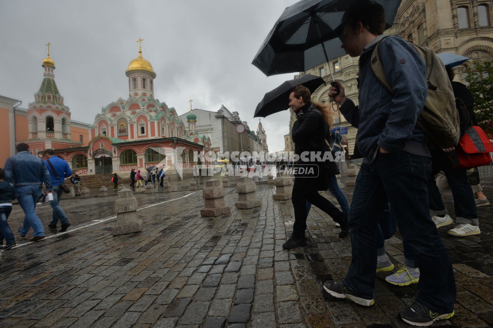 Москва. Прохожие  под зонтами на книжном фестивале `Красная площадь`.