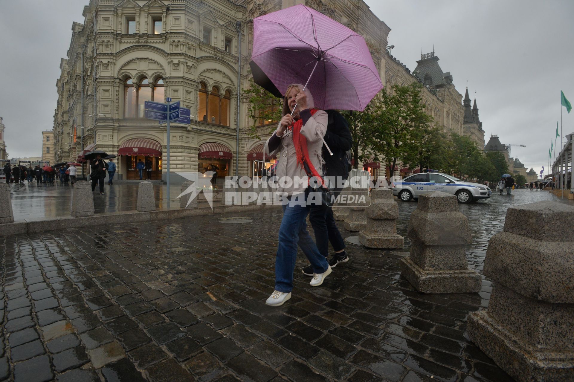 Москва. Прохожие  под зонтами  возле ГУМа.