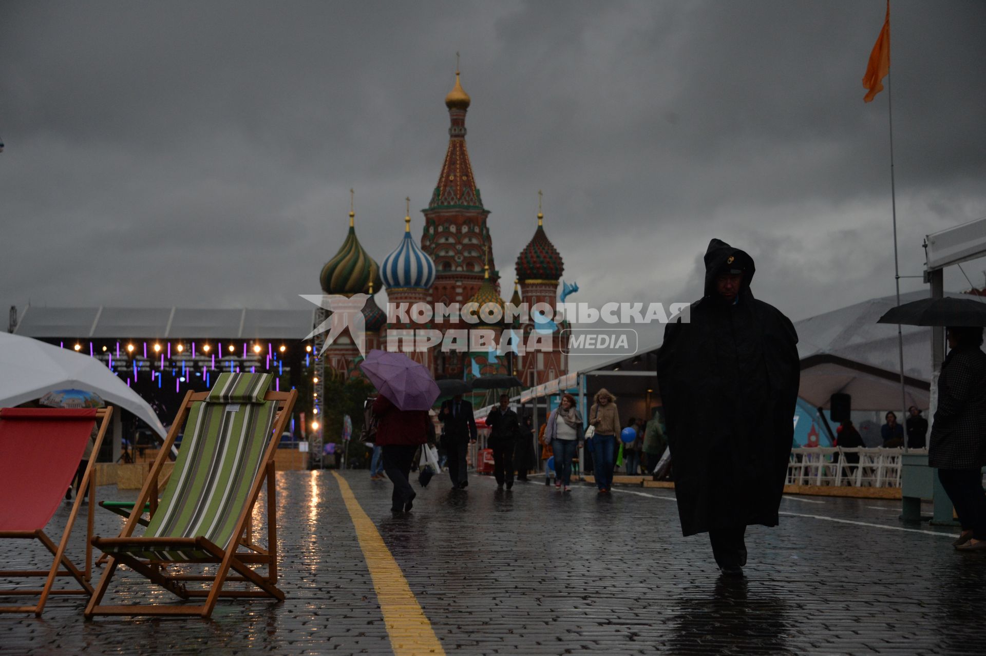 Москва. Прохожие  под зонтами на книжном фестивале `Красная площадь`.