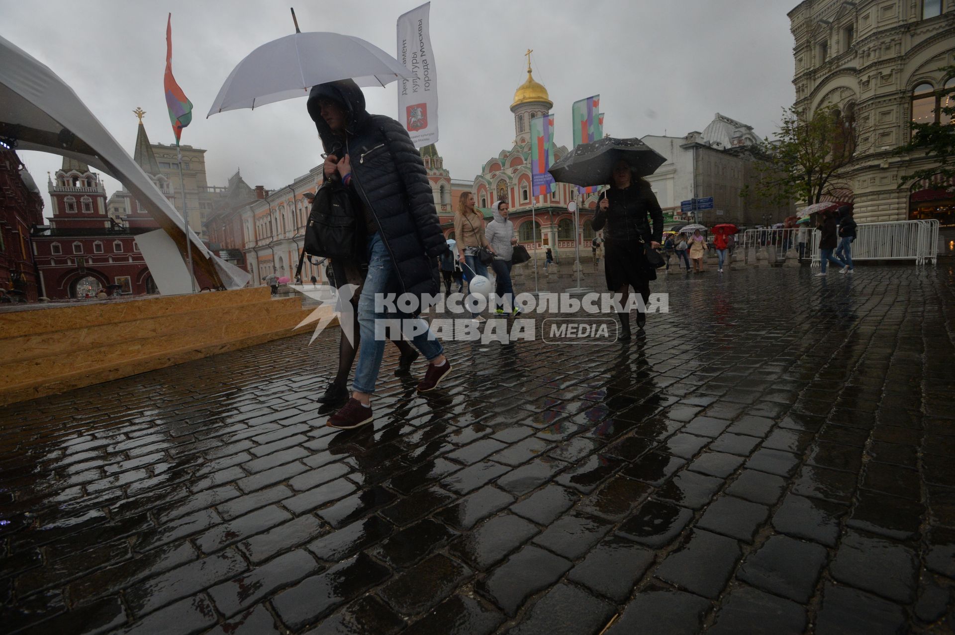 Москва. Прохожие  под зонтами на книжном фестивале `Красная площадь`.