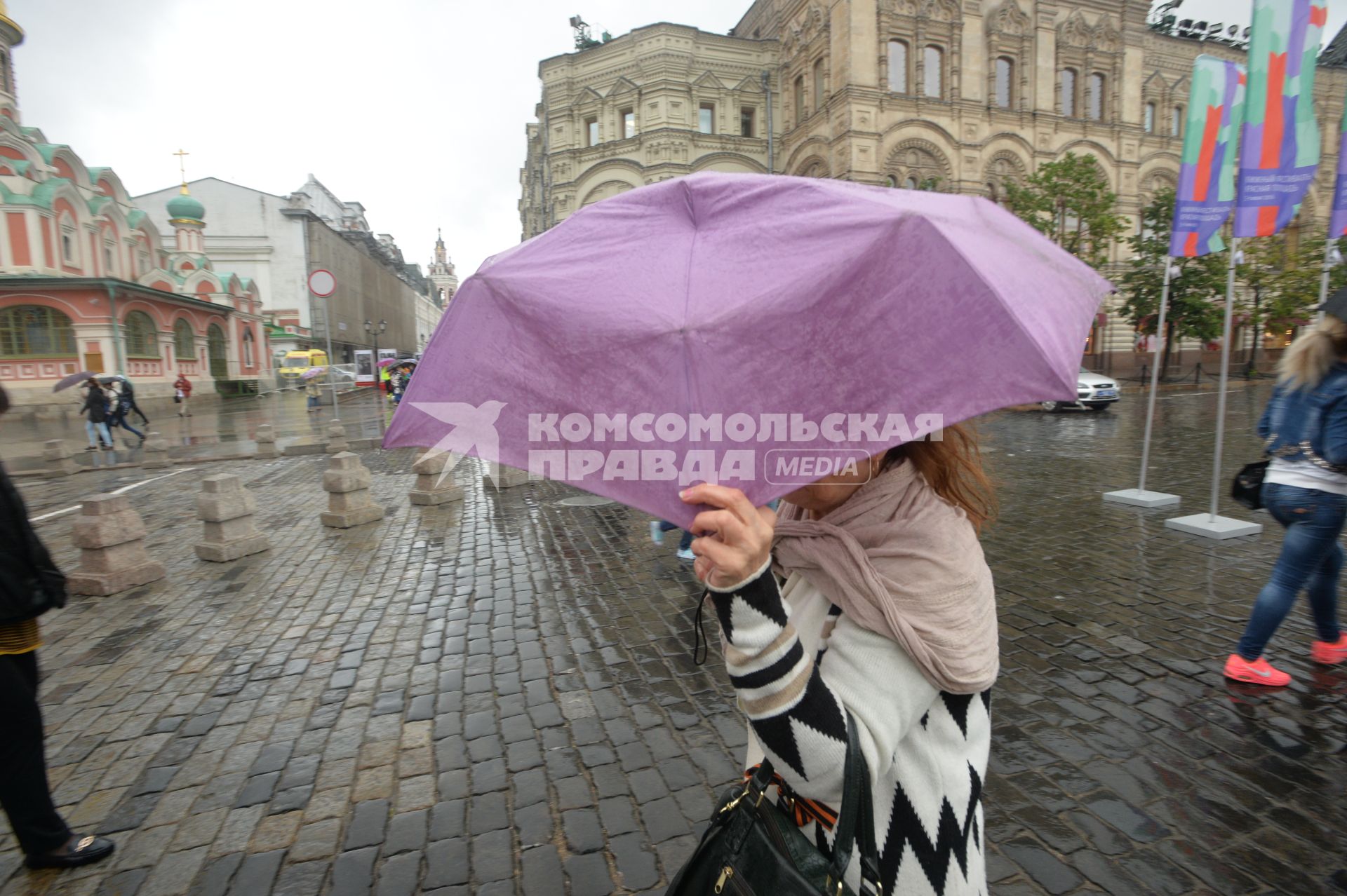 Москва. Женщина под зонтом  на Красной площади возле ГУМа.