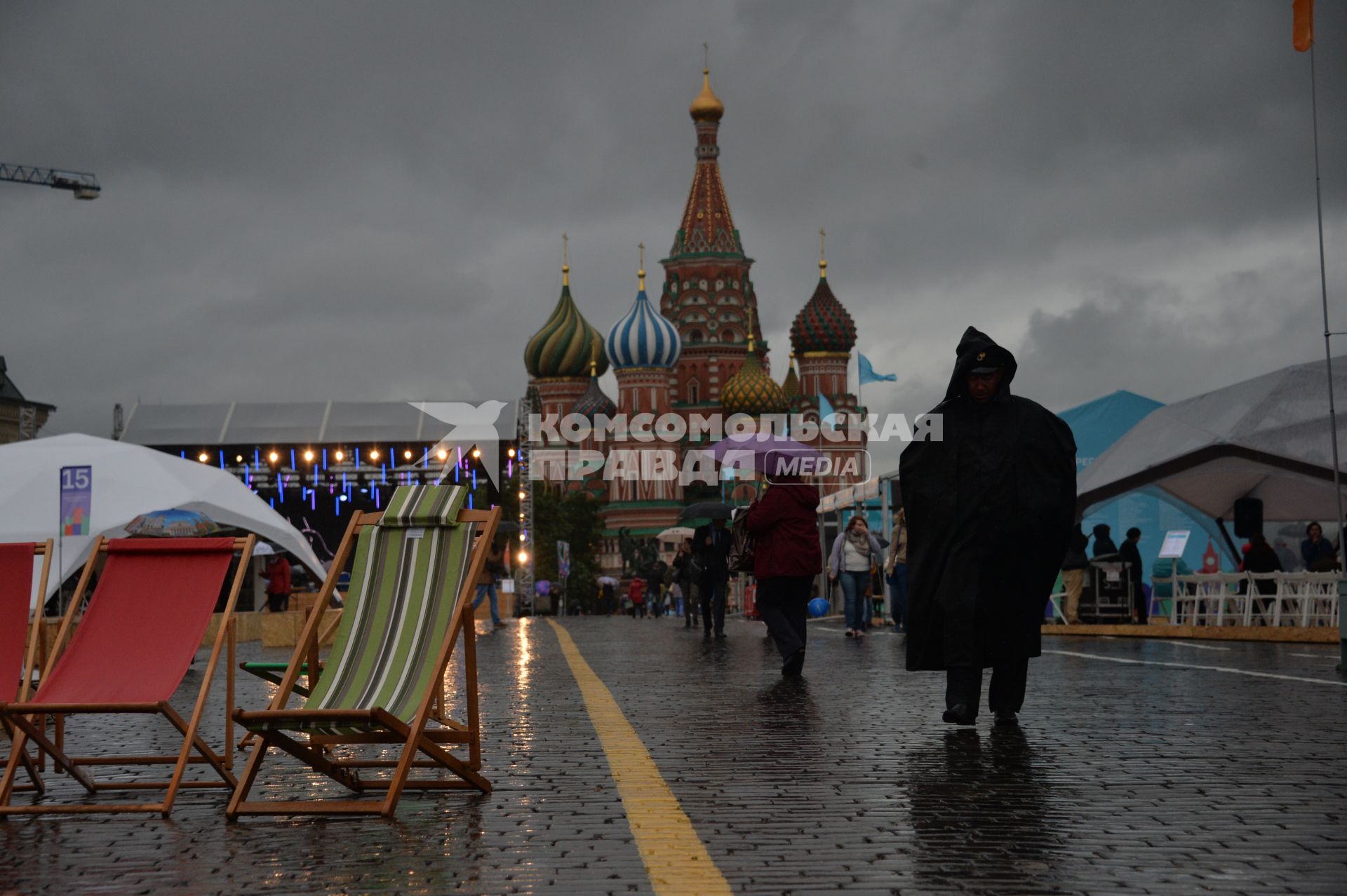 Москва. Прохожие  под зонтами на книжном фестивале `Красная площадь`.