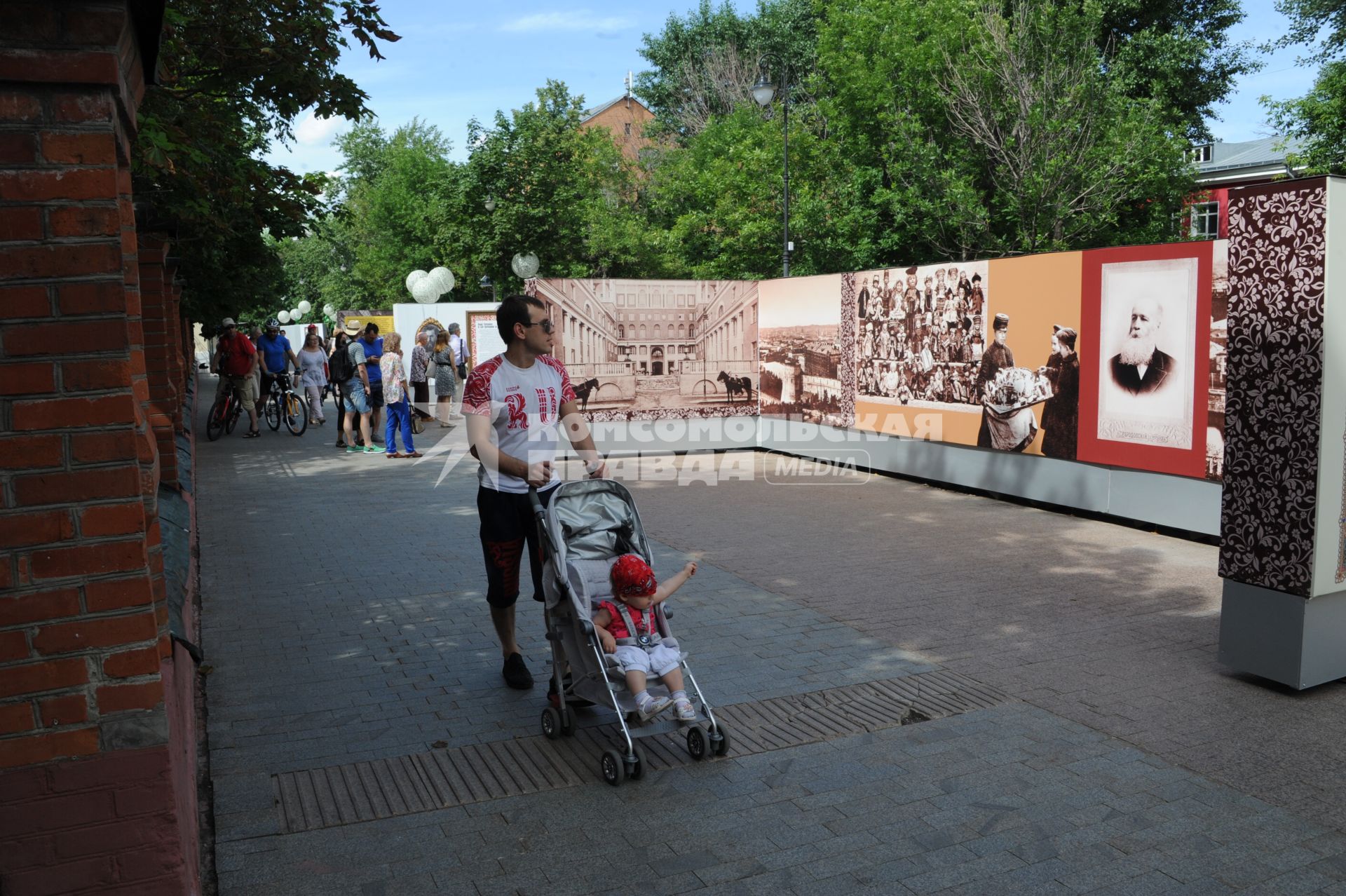 Москва. Мужчина с коляской гуляет  в историческом арт-лабиринте `Московская летопись`, который расположился в   Лаврушинском переулке .