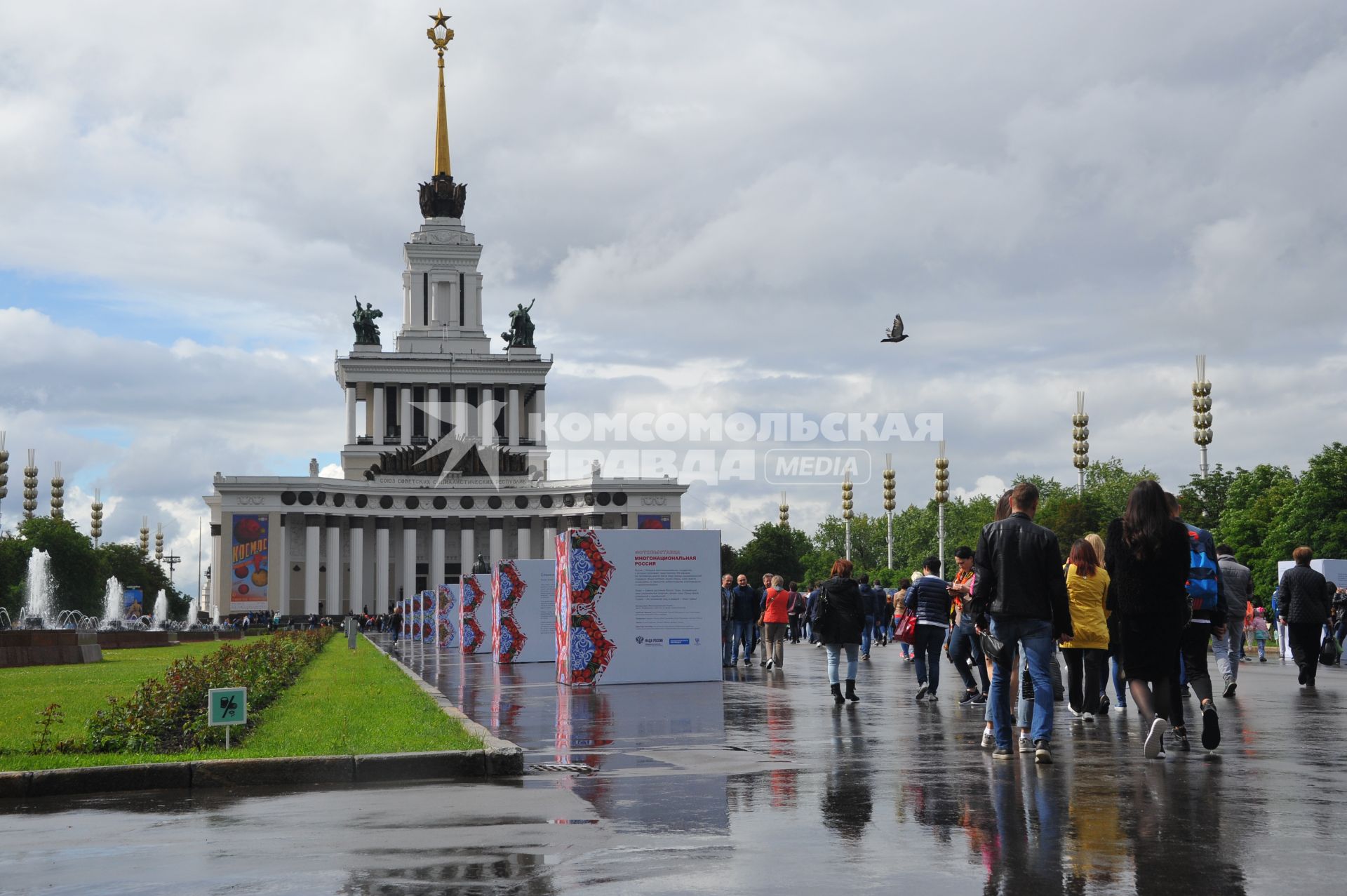 Москва.   Прохожие на   центральной аллее ВДНХ ,где открылась  фотовыставка  `Многонациональная Россия`.