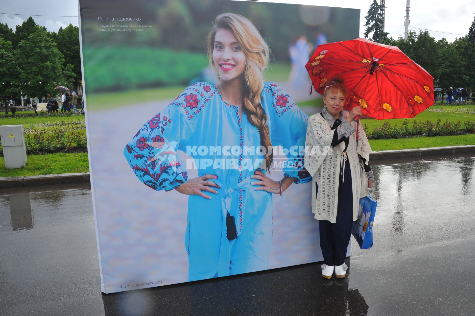 Москва.   Женщина под зонтом на   центральной аллее ВДНХ ,где открылась  фотовыставка  `Многонациональная Россия`.