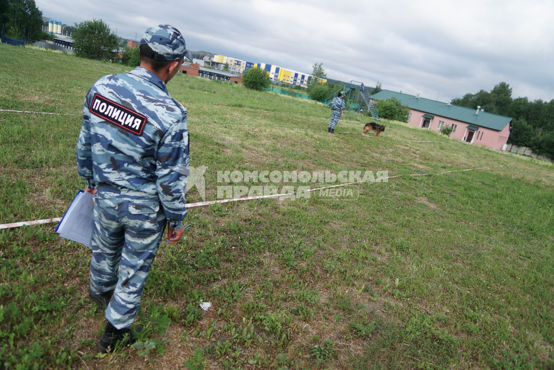 Екатеринбург. Судья наблюдает как полицейский-кинолог с своей служебной собакой выполняют задание на областных соревнованиях кинологов МВД и Таможни