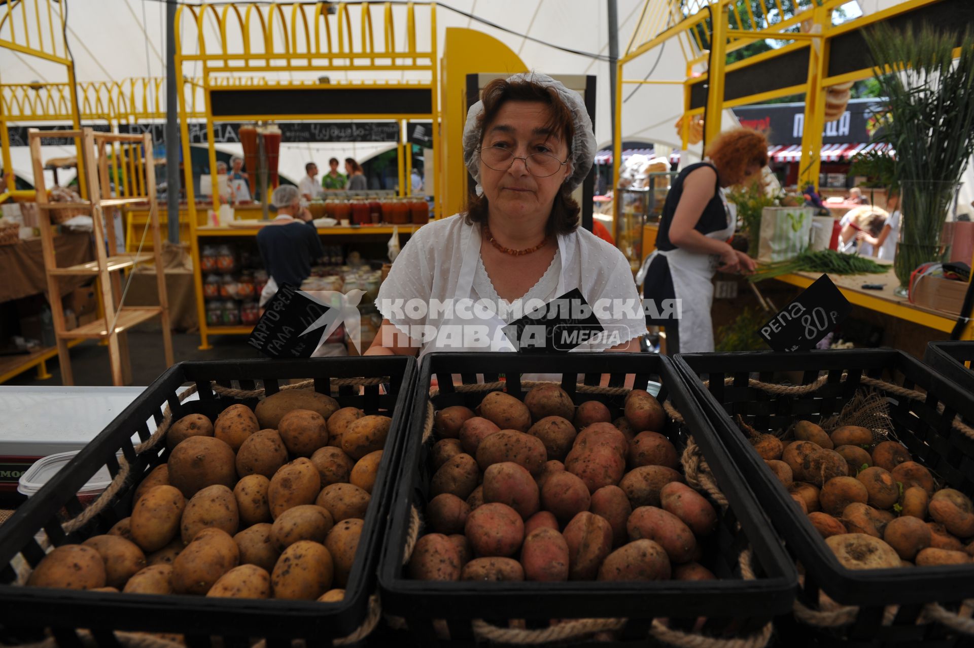 Москва.  Женщина продает картофель  на ярмарке выходного дня на ВДНХ.