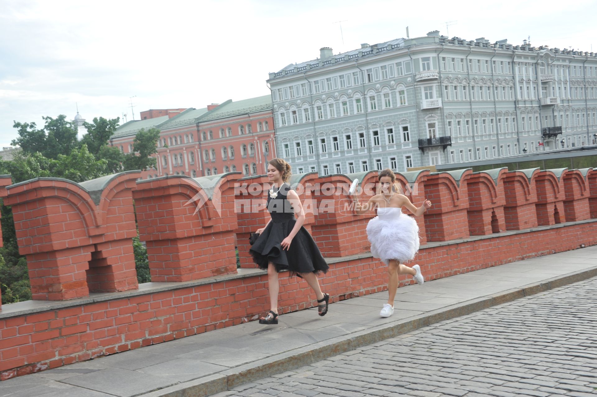 Москва. Выпускницы бегут по Троицкому мосту.