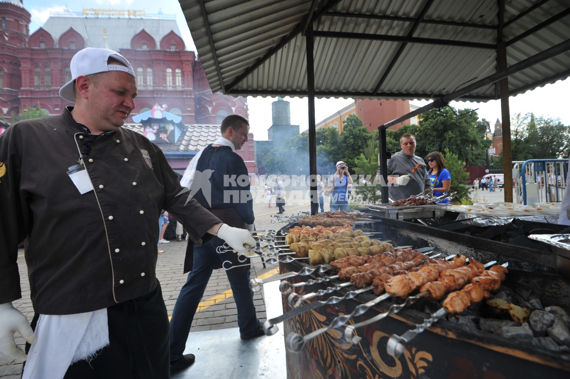 Москва.   Мужчина жарит шашлык на Манежной площади.