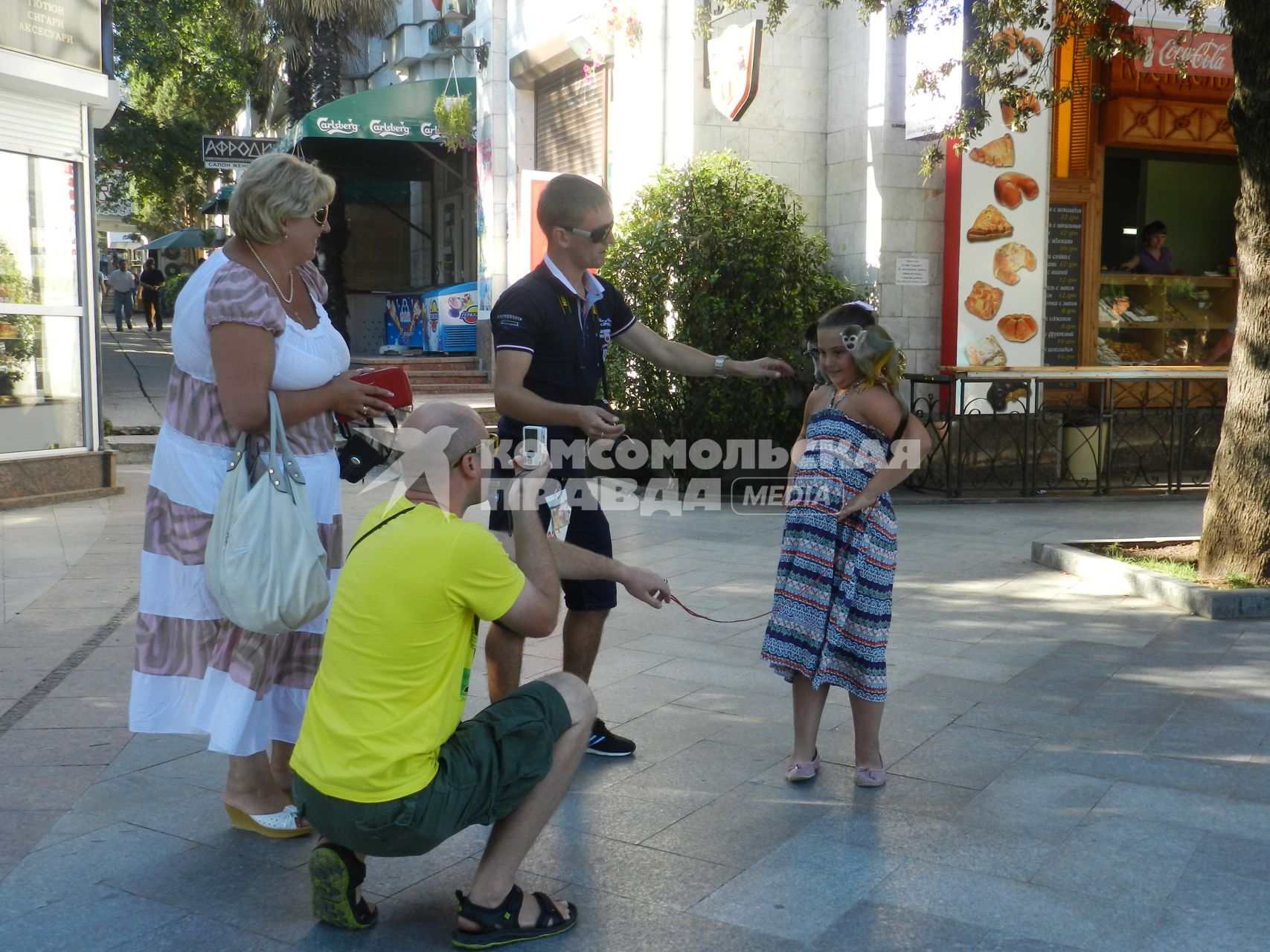 Украина, Крым. Девочка фотографируется с обезьянкой.