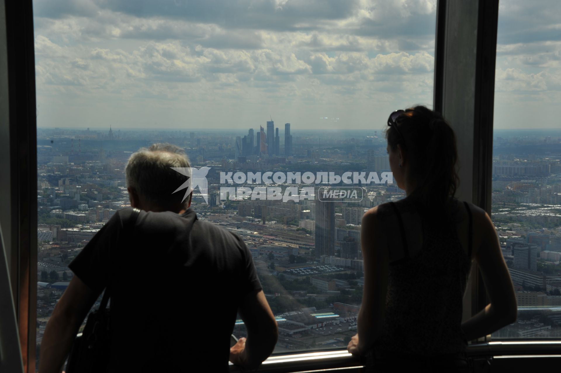 Москва.  Мужчина и девушка смотрят на город со смотровой площадки Останкинской телебашни.