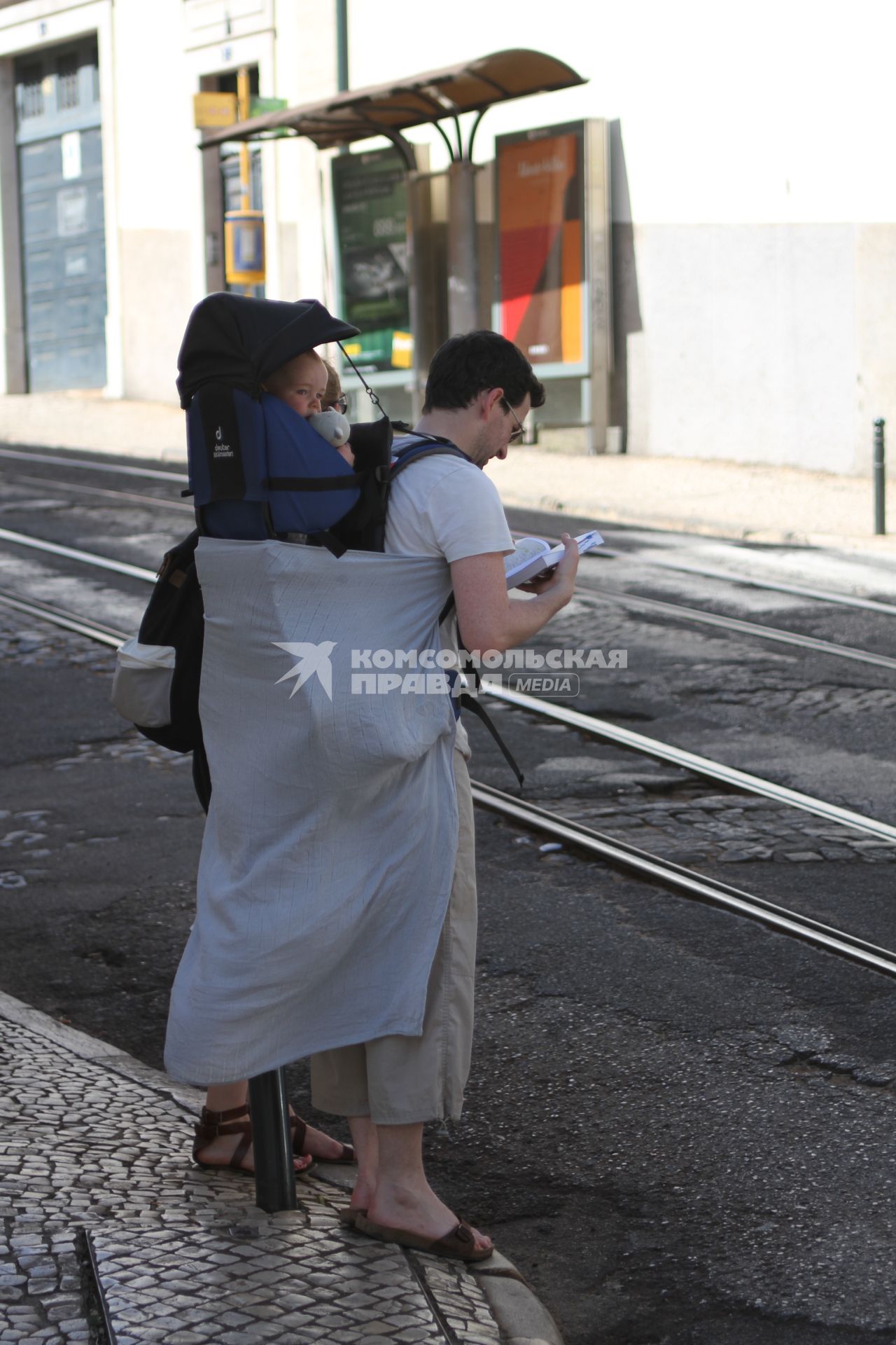 Португалия. Лиссабон.  Мужчина с ребенком на одной из улиц города.