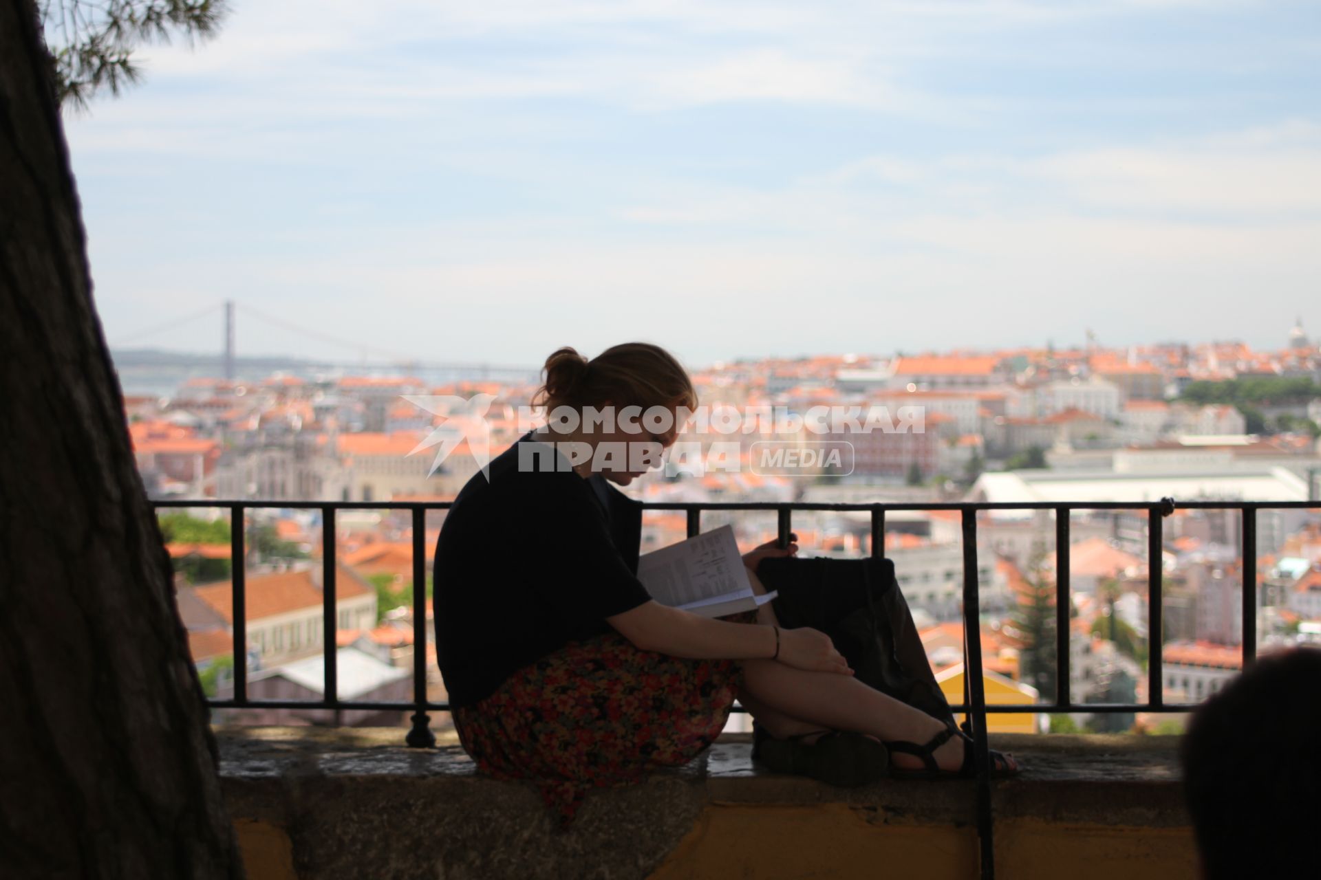 Португалия. Лиссабон.  Девушка читает книгу.