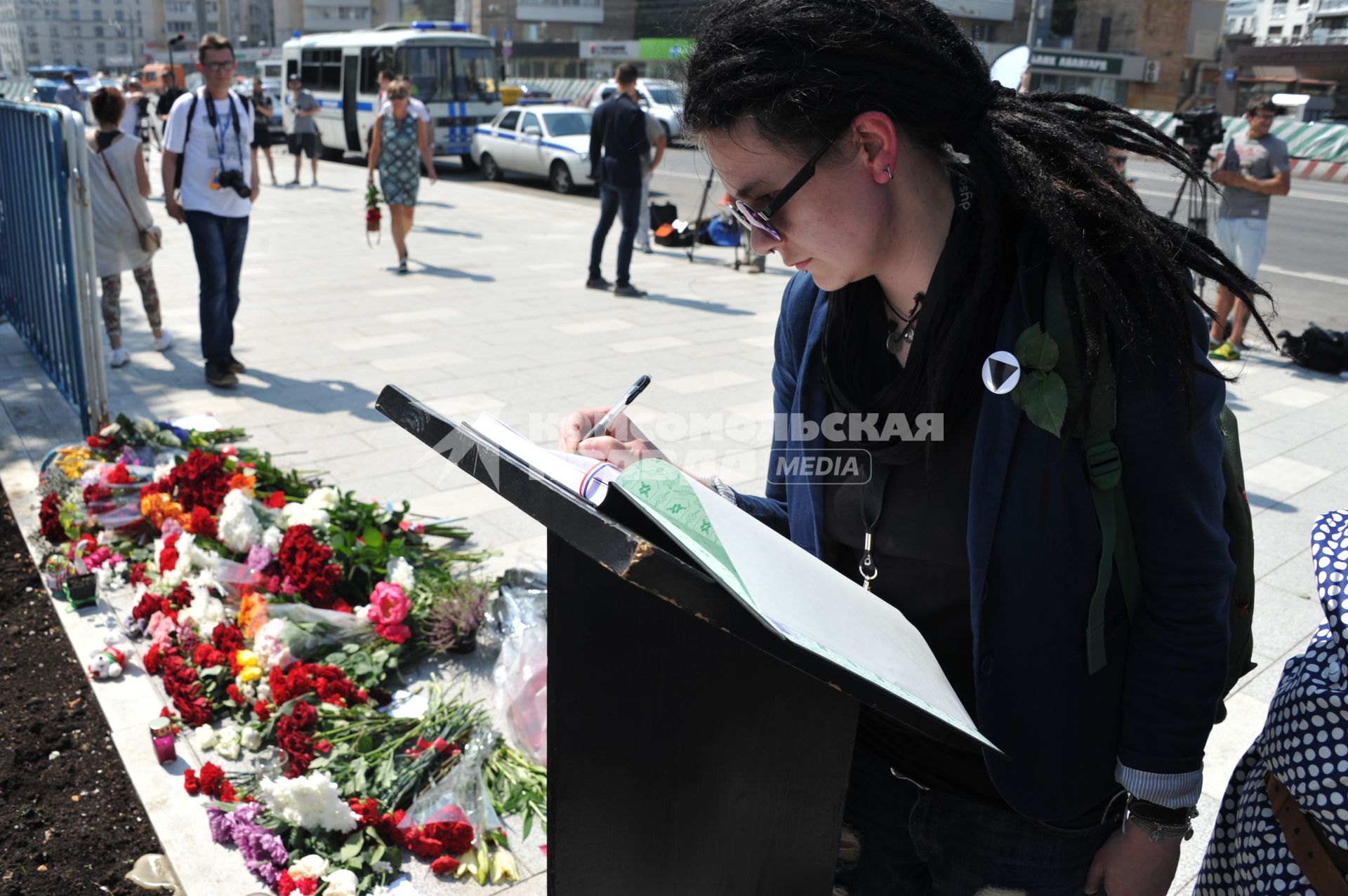 Москва.  Прохожие возлагают цветы и свечи у посольства Франции в на Большой Якиманке в память о погибших в результате террористического акта в Ницце.