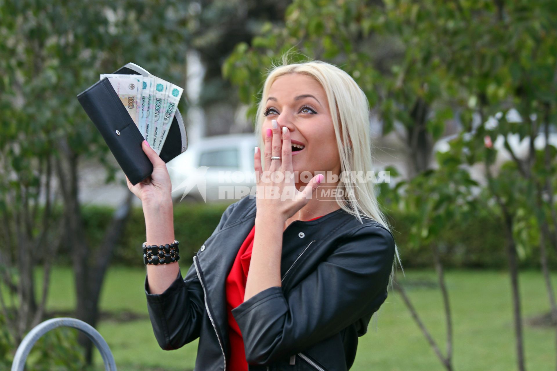 Уфа. Девушка держит в руке кошелек с деньгами.