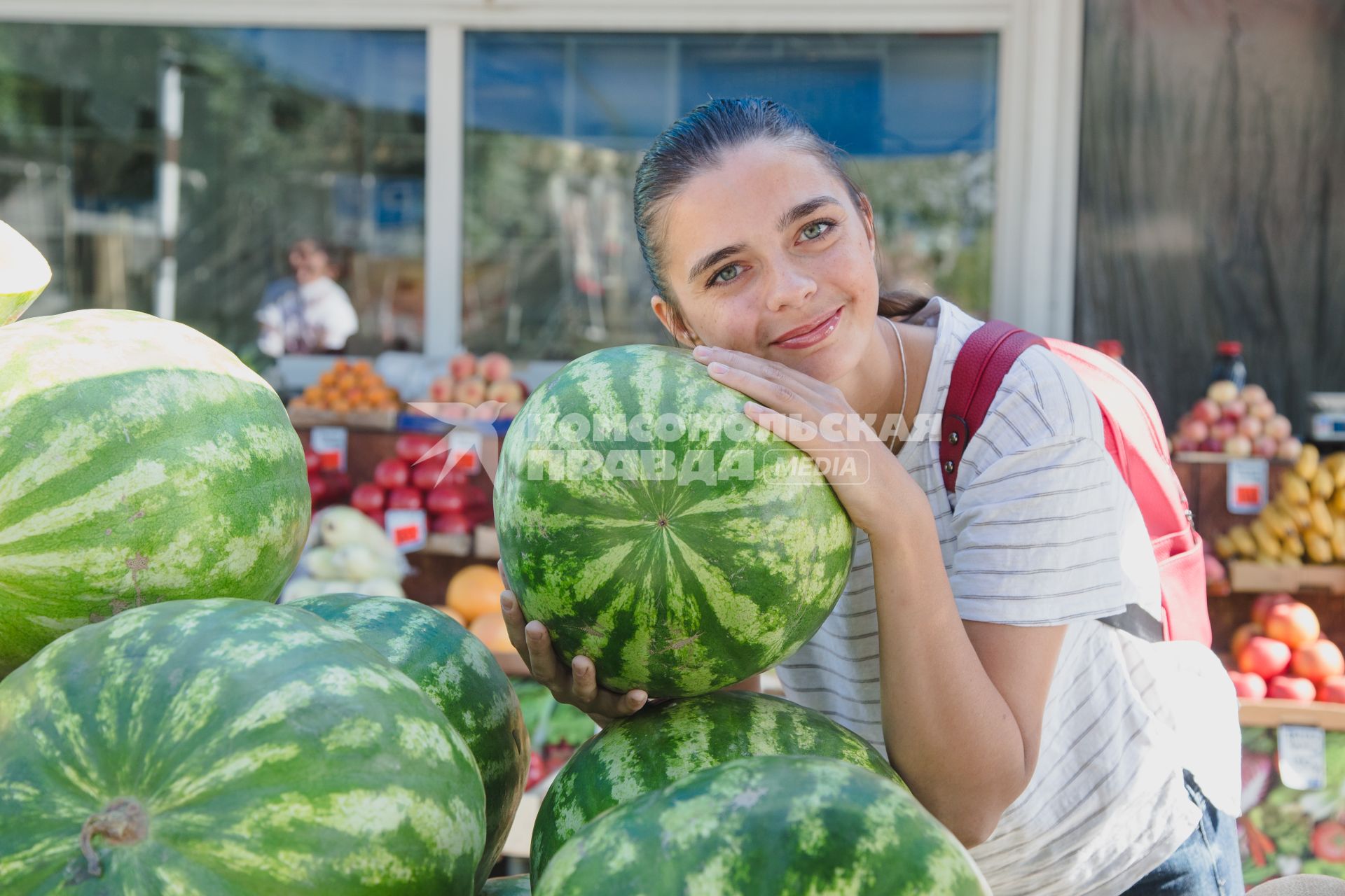 Челябинск. Девушка выбирает арбуз на рынке.