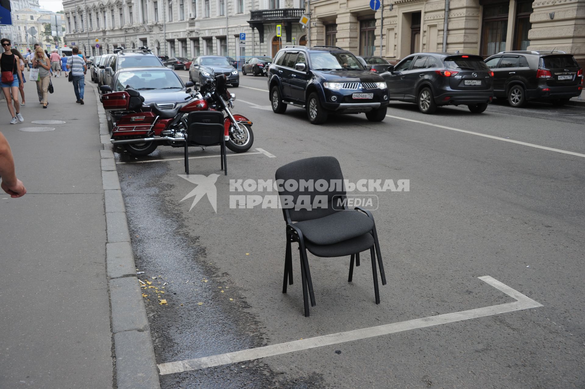 Москва. Парковочное место на улице Ильинка, огороженное офисными стульями.