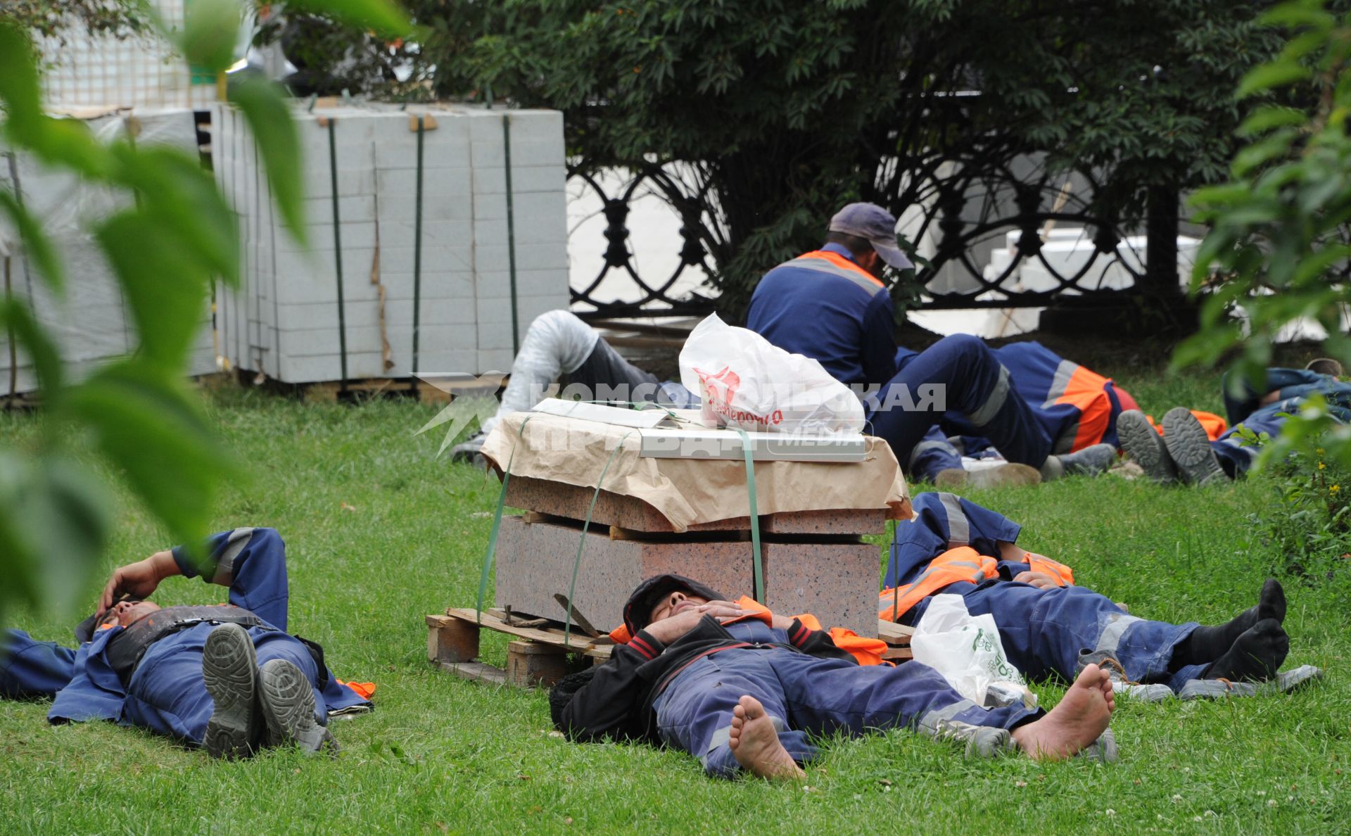 Москва.   Рабочие спят на газоне во время обеденного перерыва.