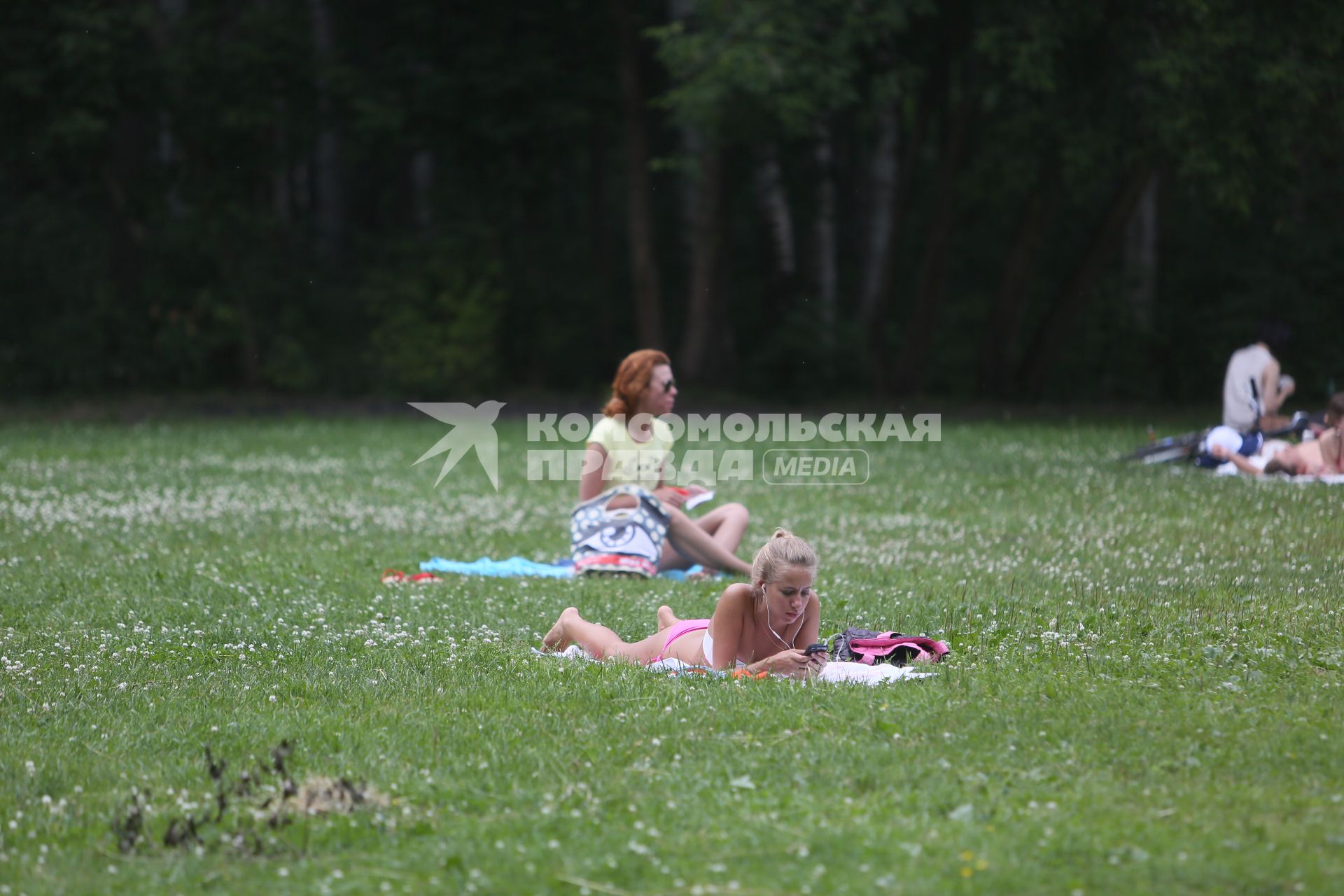 Санкт-Петербург. Девушки загорают на газоне в парке.