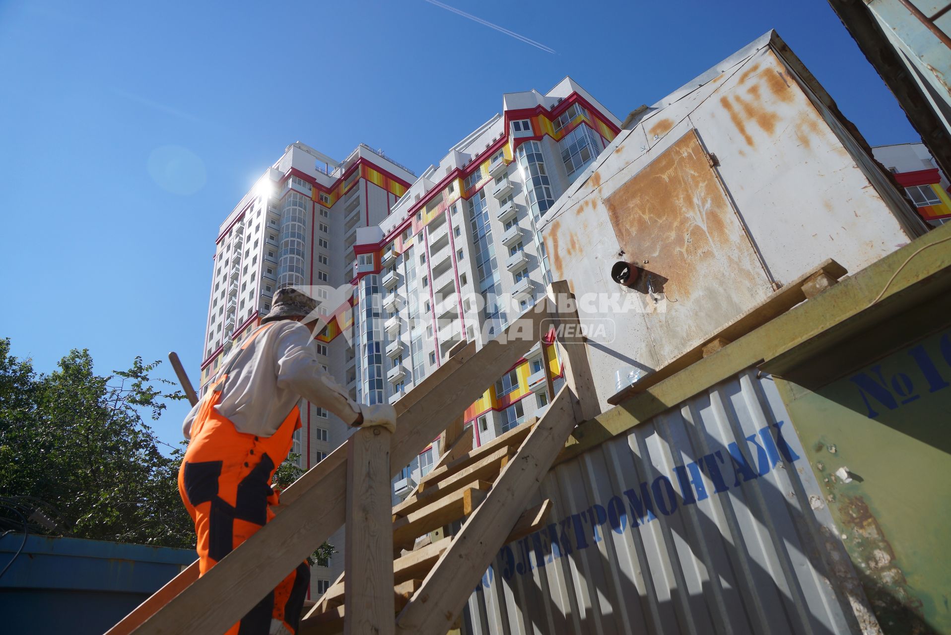 Екатеринбург. Строитель поднимается в рабочую бытовку. Строительство многоэтажного дома