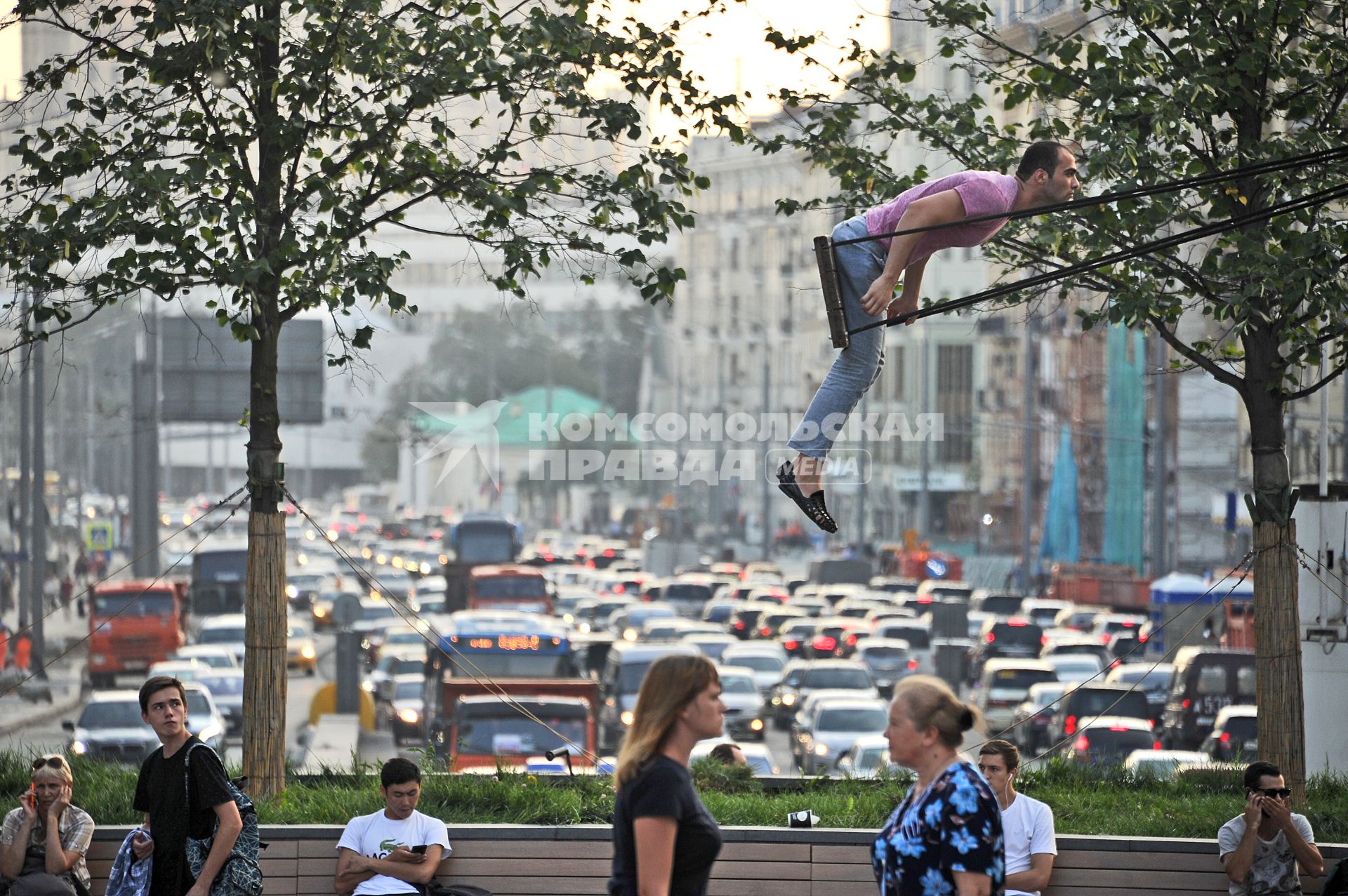 Москва.  Мужчина качается на качелях на Триумфальной площади.