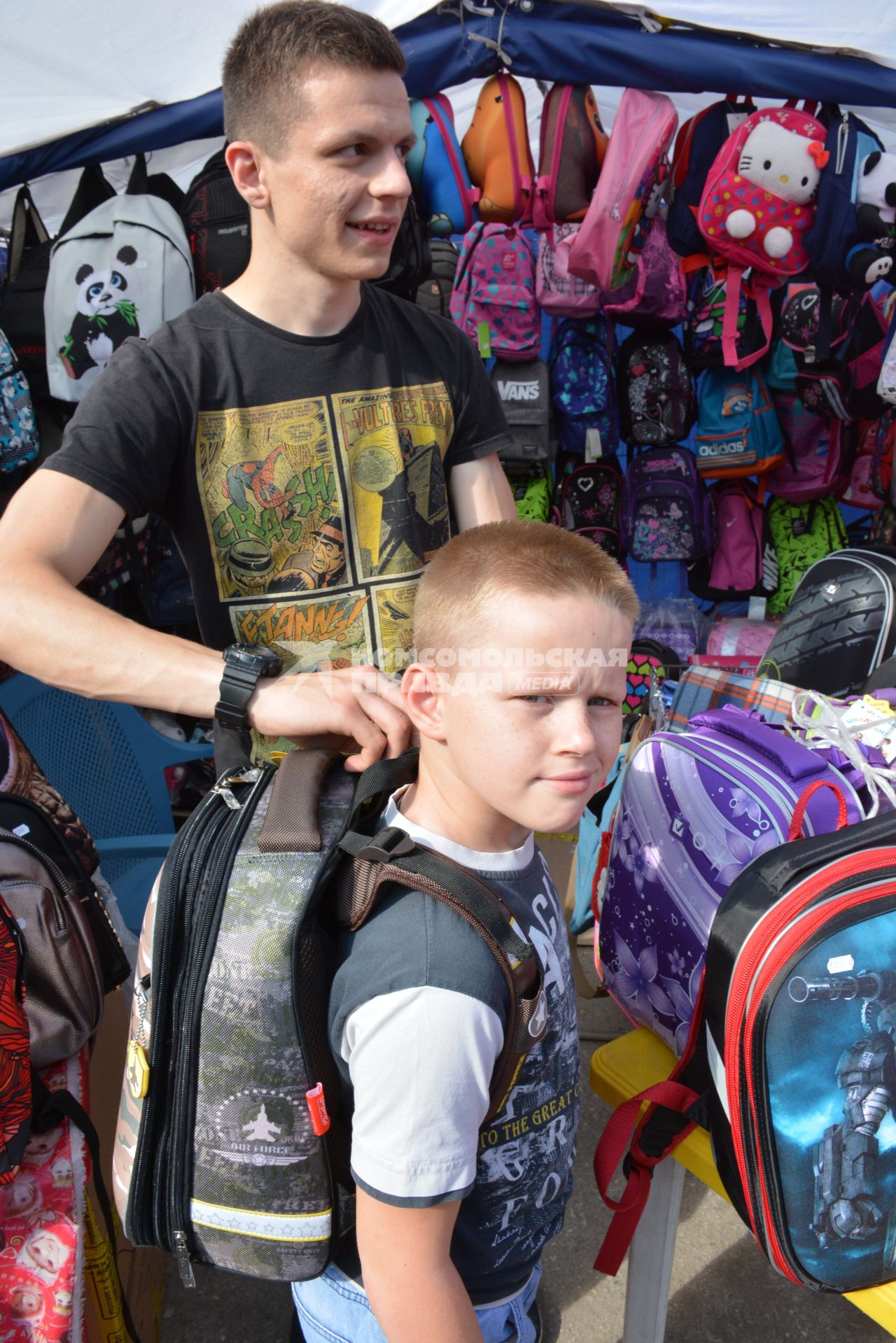 Новосибирск. Мальчик выбирает рюкзак на школьном базаре.