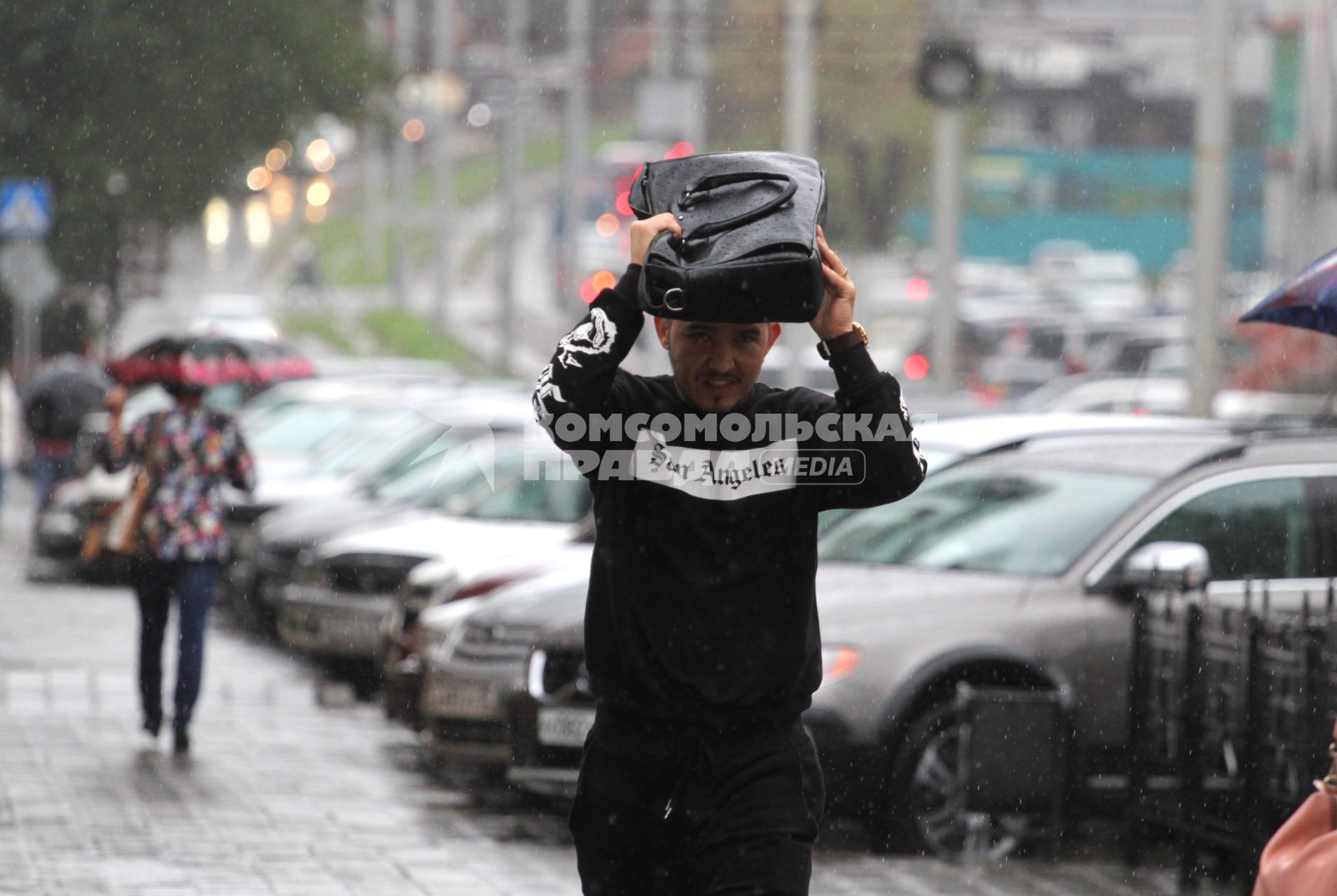 Иркутск.  Мужчина во время дождя на одной из улиц города.