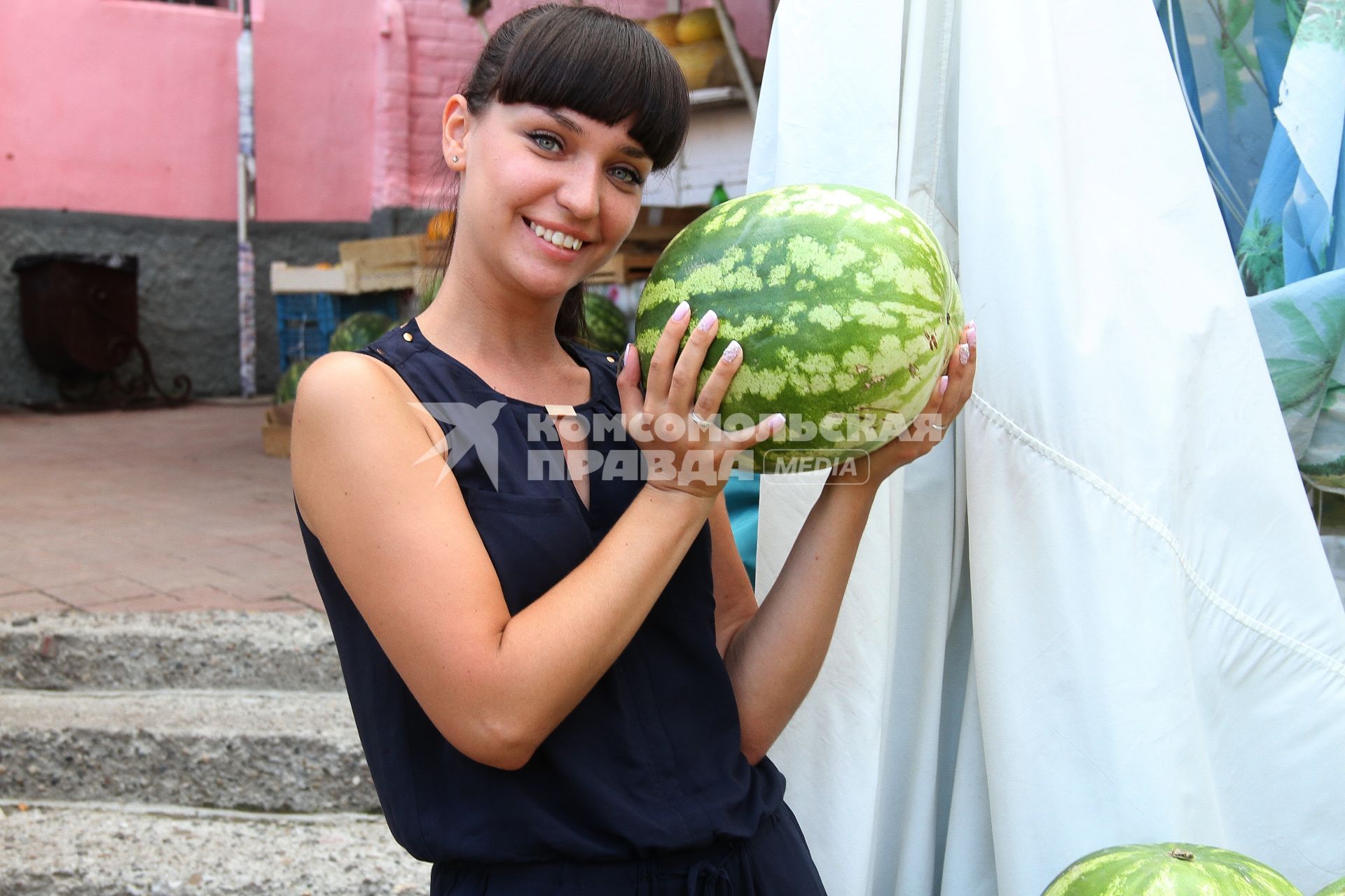 Нижний Новгород. Девушка выбирает арбуз на рынке .