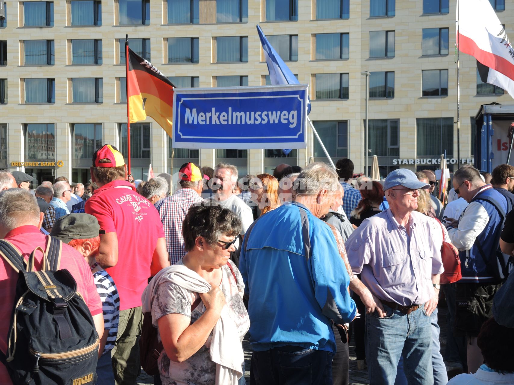 Германия,Дрезден.  Митингующие на улице города. Плакат`Меркель должна уйти`.