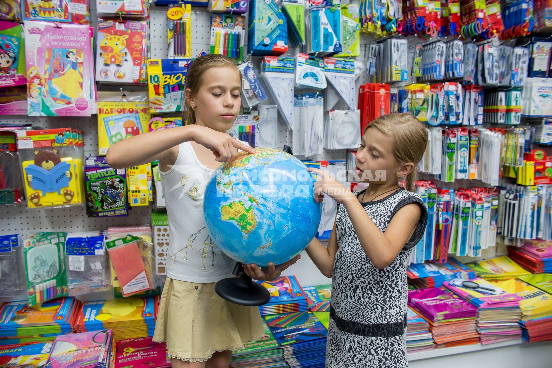 Челябинск. Девочки выбирают глобус в отделе школьных товаров.