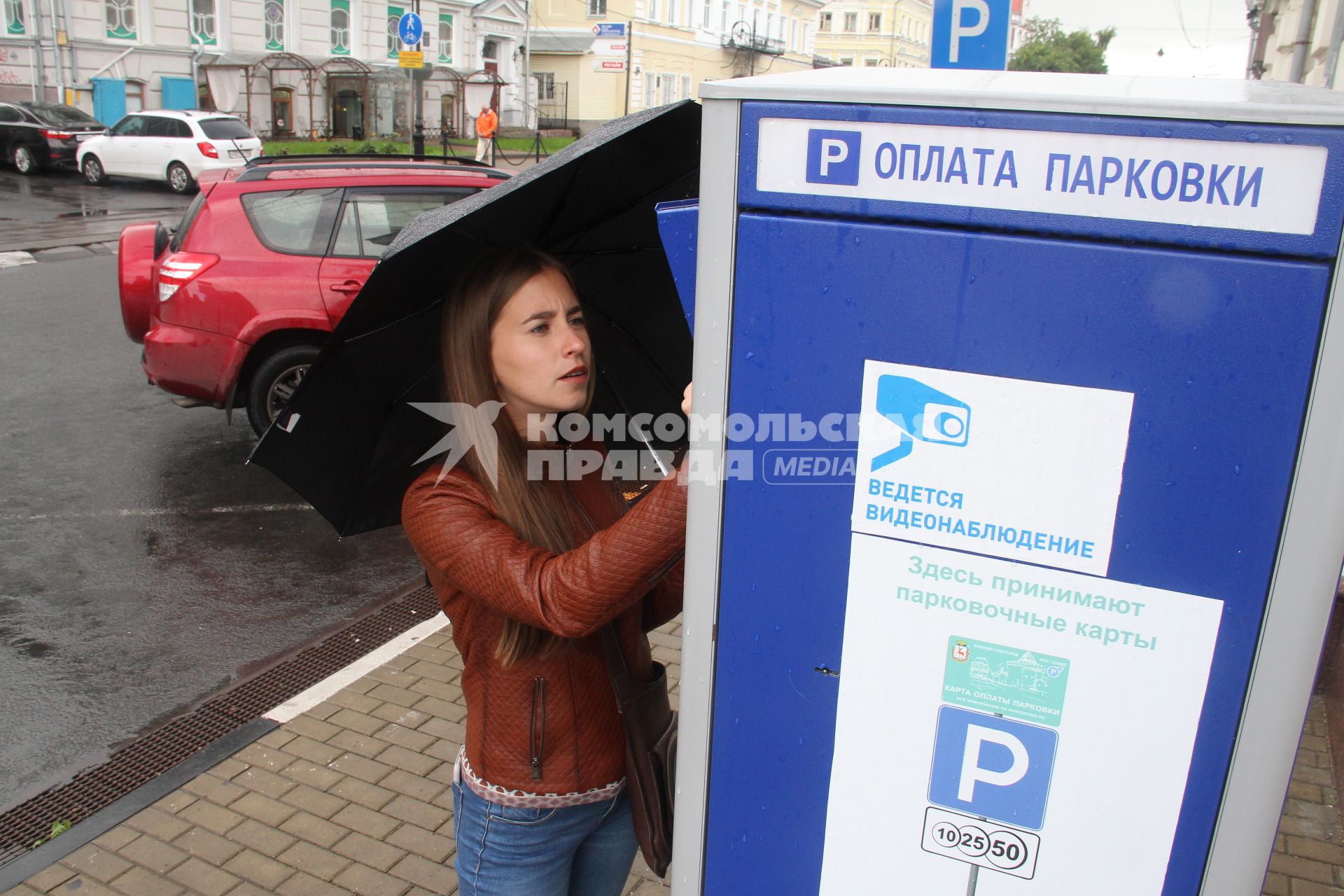 Нижний Новгород. Девушка оплачивает парковку на одной из улиц города.