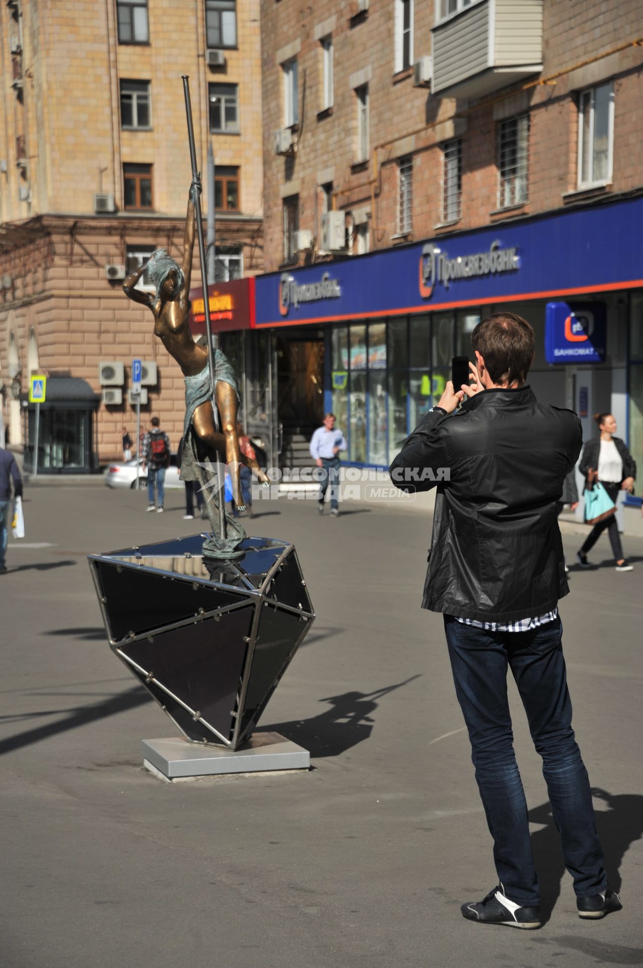 Москва.   Мужчина фотографирует памятник стриптизерше на улице Проспект Мира.