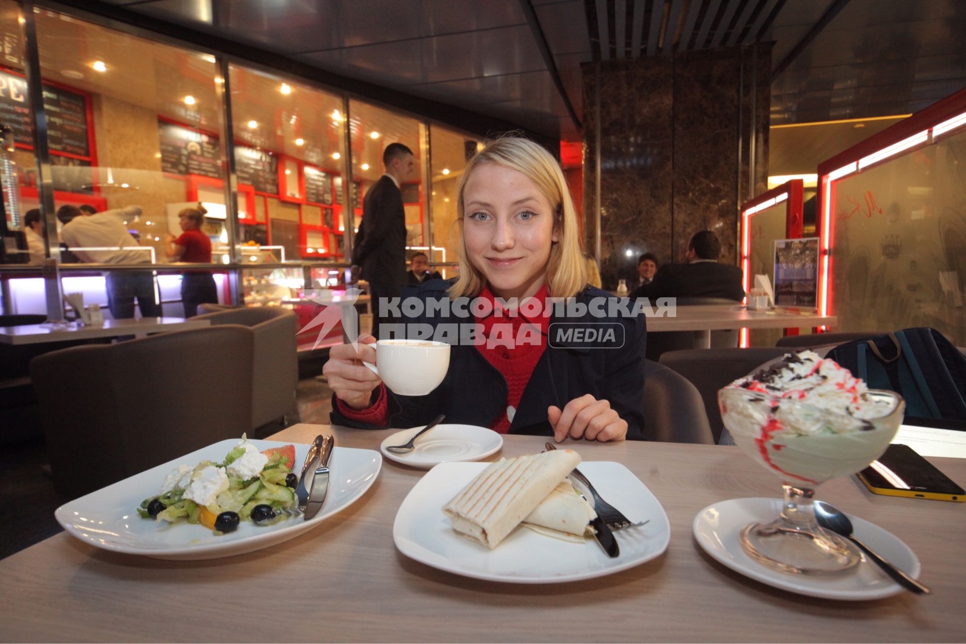 Москва. Девушка за столиком  в первой кофейне при московском  метро `М Кафе` на станции   `Выставочная` .