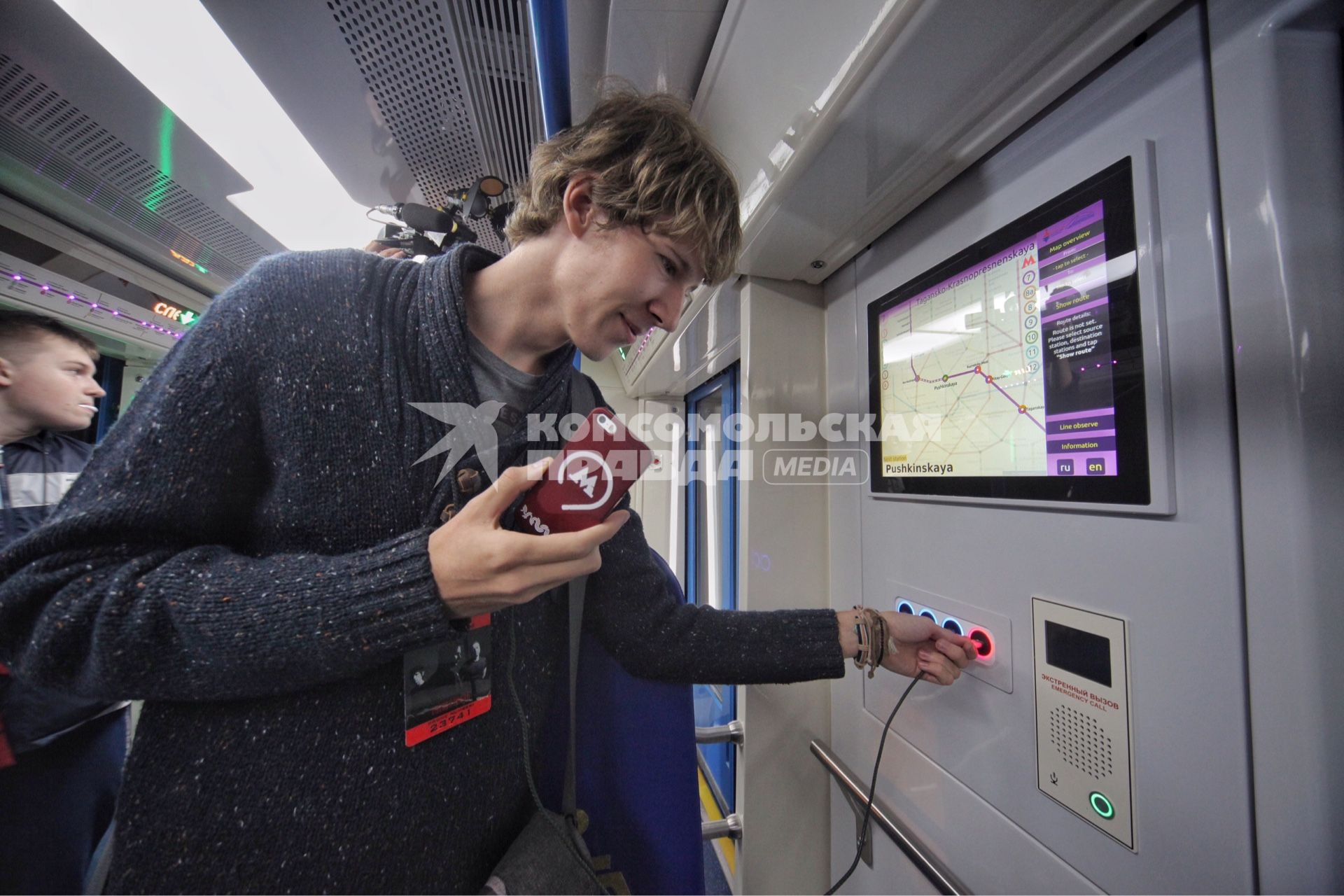 Москва. Во время презентации инновационного подвижного состава для метрополитена 765-й серии `Москва` на выставочной площадке ВДНХ. Молодой человек заряжает мобильный телефон.