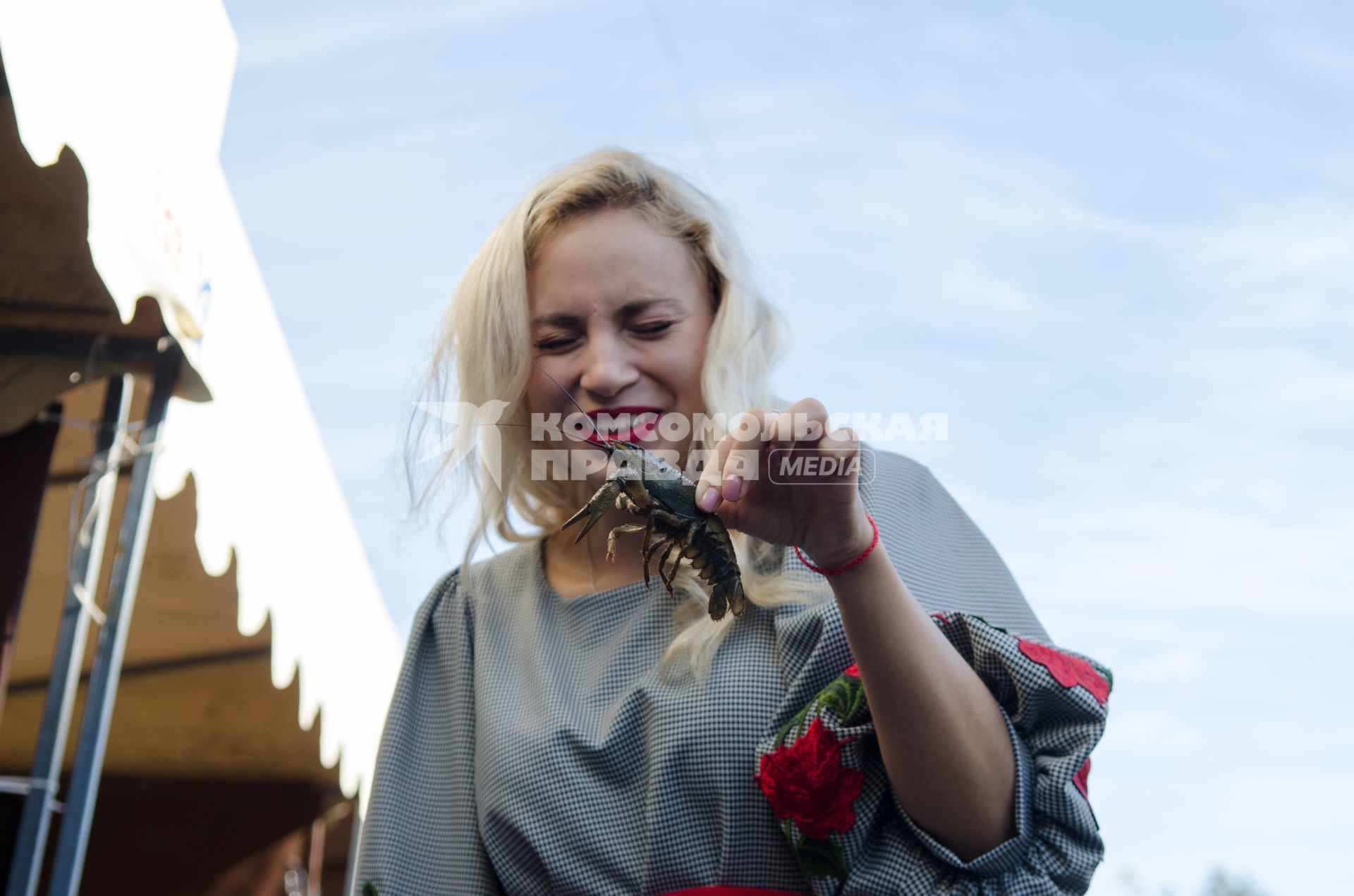 Самара.  Посетительница ярмарки   держит в руке рака.