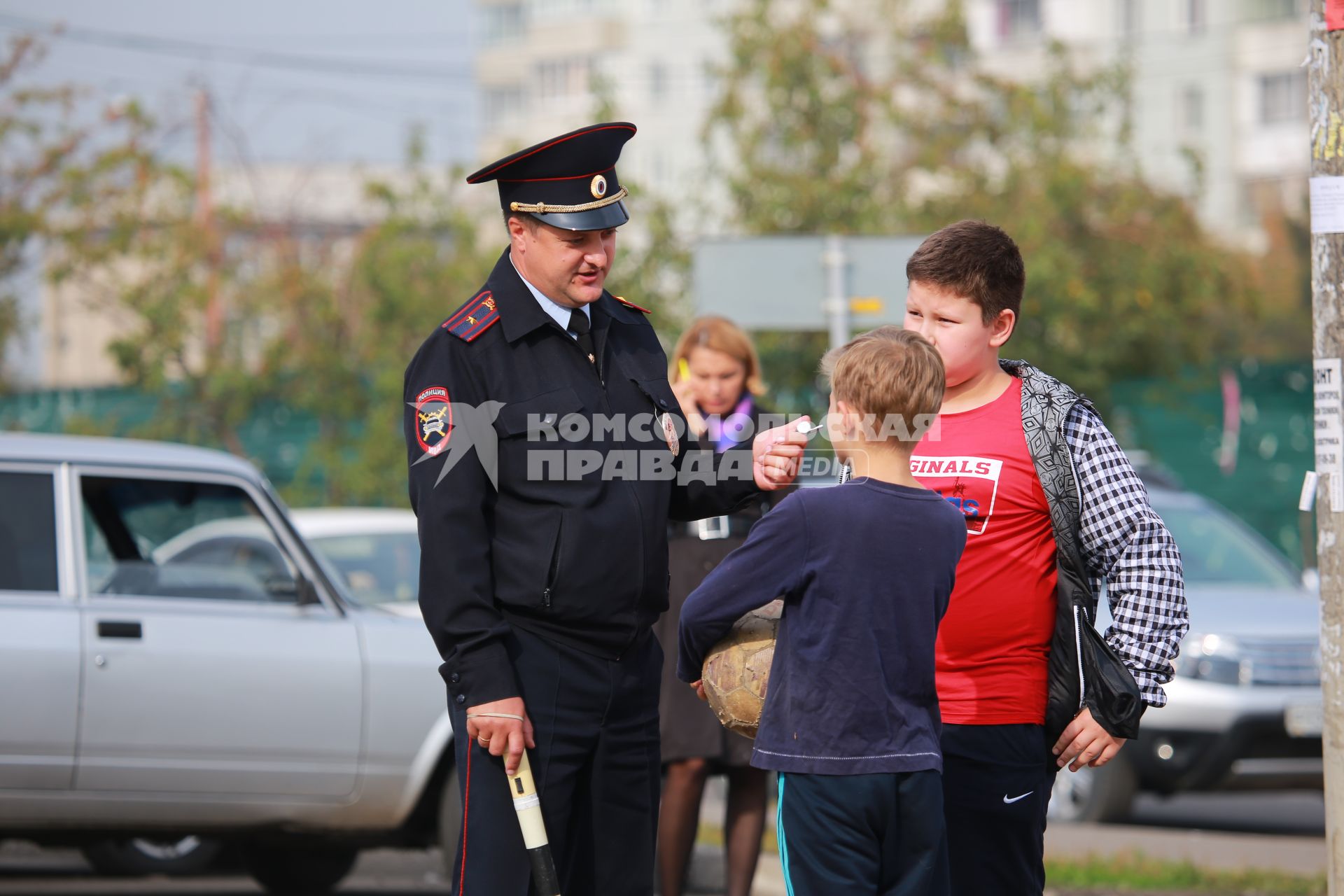 Красноярск. Сотрудник  ГИБДД разговаривает с детьми на одной из улиц города.