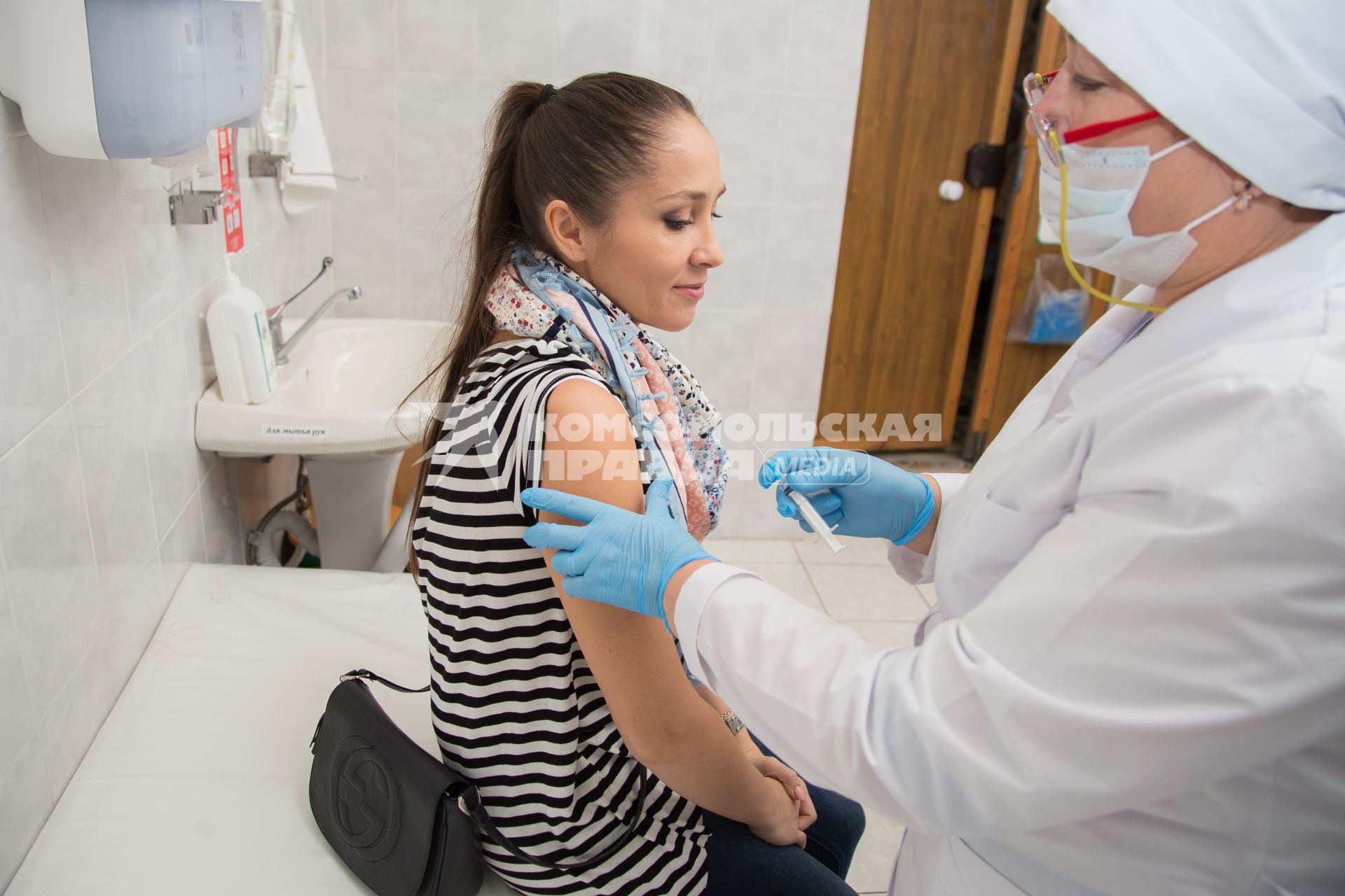 Челябинск. Девушка  в поликлиннике делает прививку от гриппа.