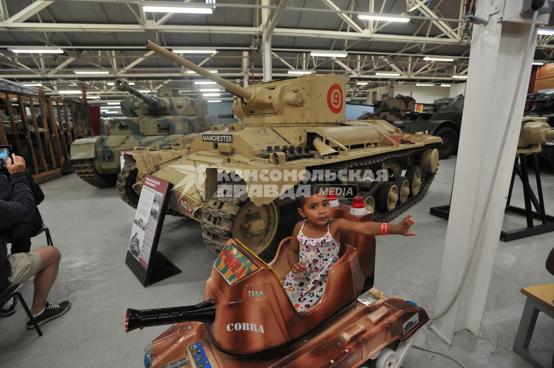 Англия. Лондон. Девочка играет с макетом танка cobra  в одном из залов  музея танков в Бовингтоне.