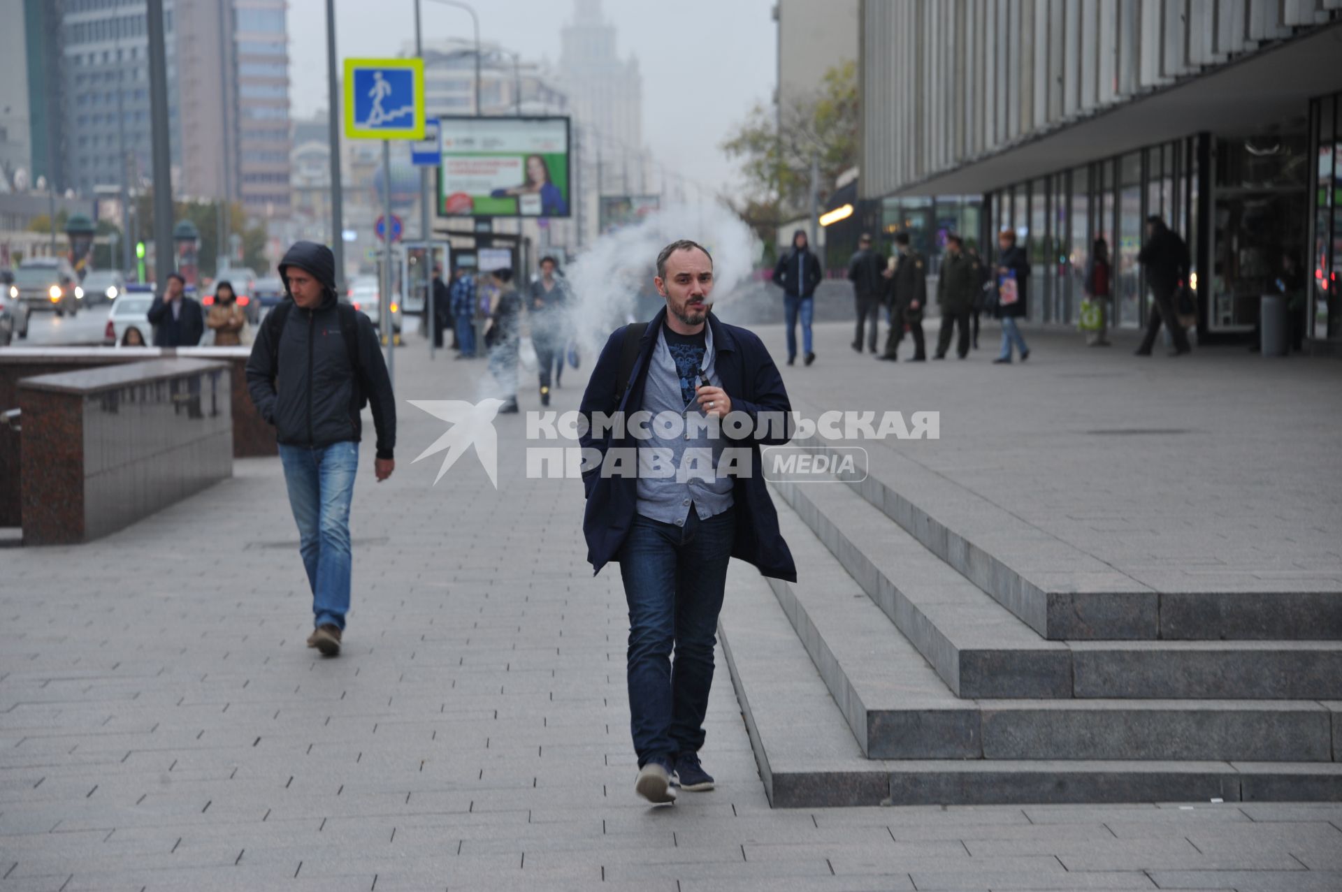 Москва. Мужчина курит электронную сигарету  на Новом Арбате.