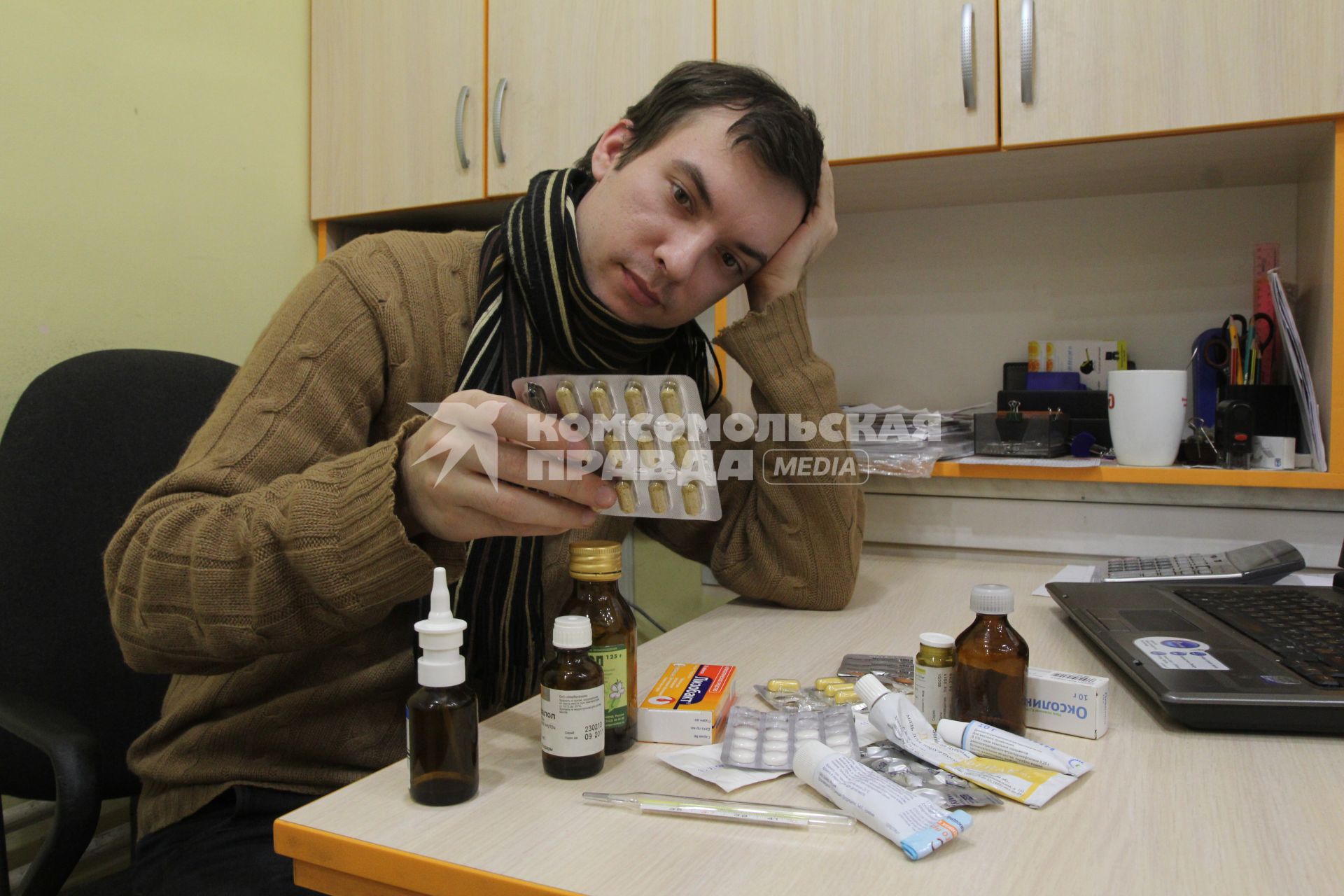 Иркутск.  Мужчина на рабочем месте в офисе  лечится от простуды.