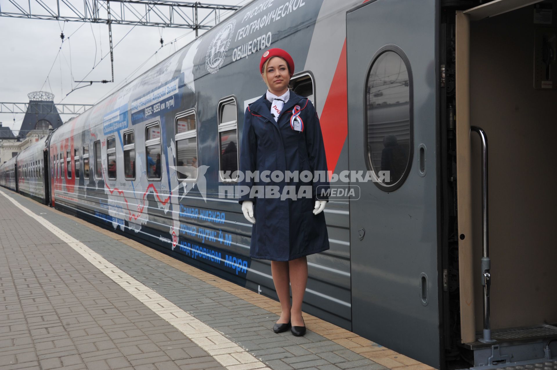 Москва. Проводница рядом с  вагоном юбилейного фирменного поезда  `100 лет Трансибу` перед отправлением его во Владивосток с Ярославского вокзала.