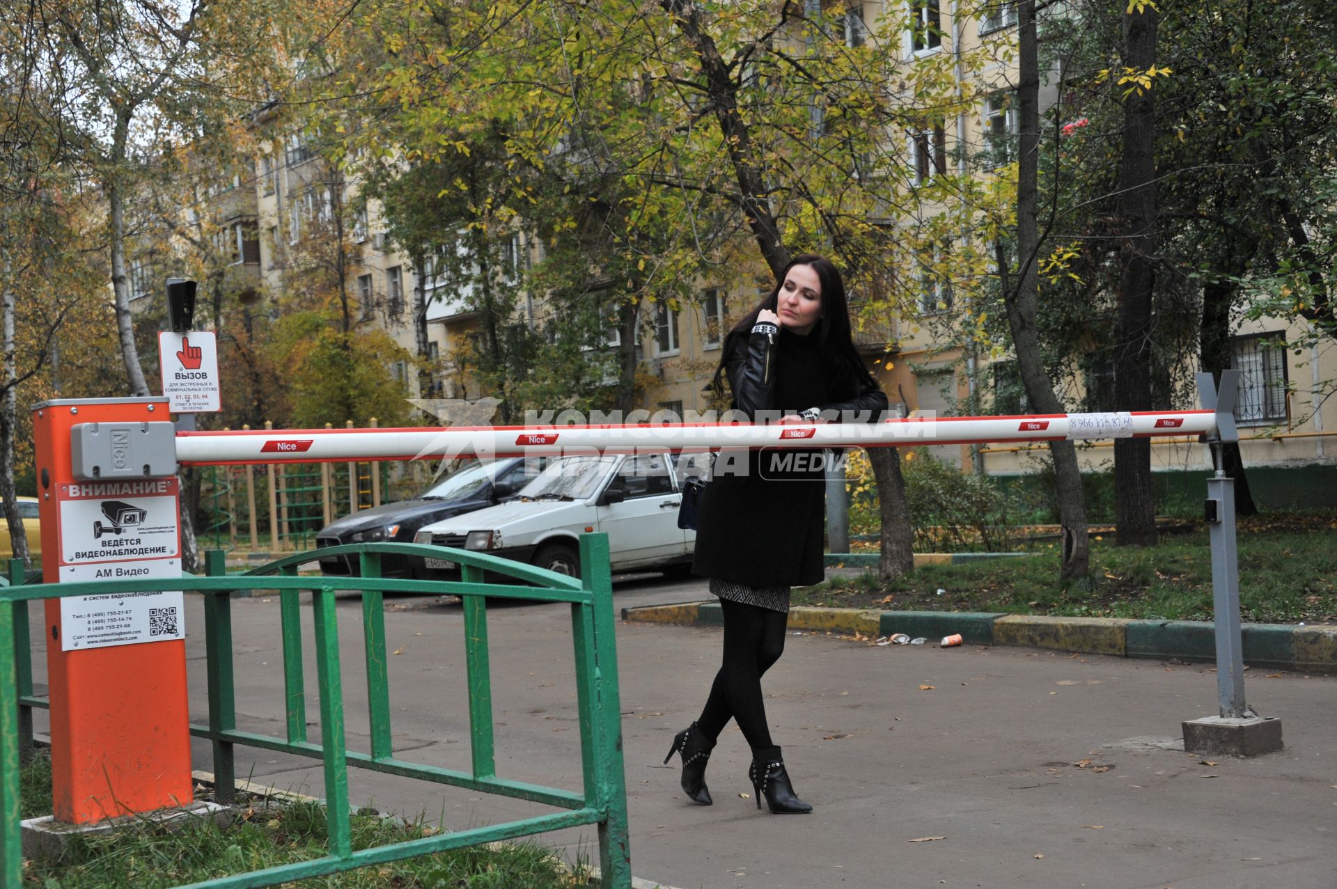 Москва.   Девушка у шлагбаума  во дворе жилого дома.