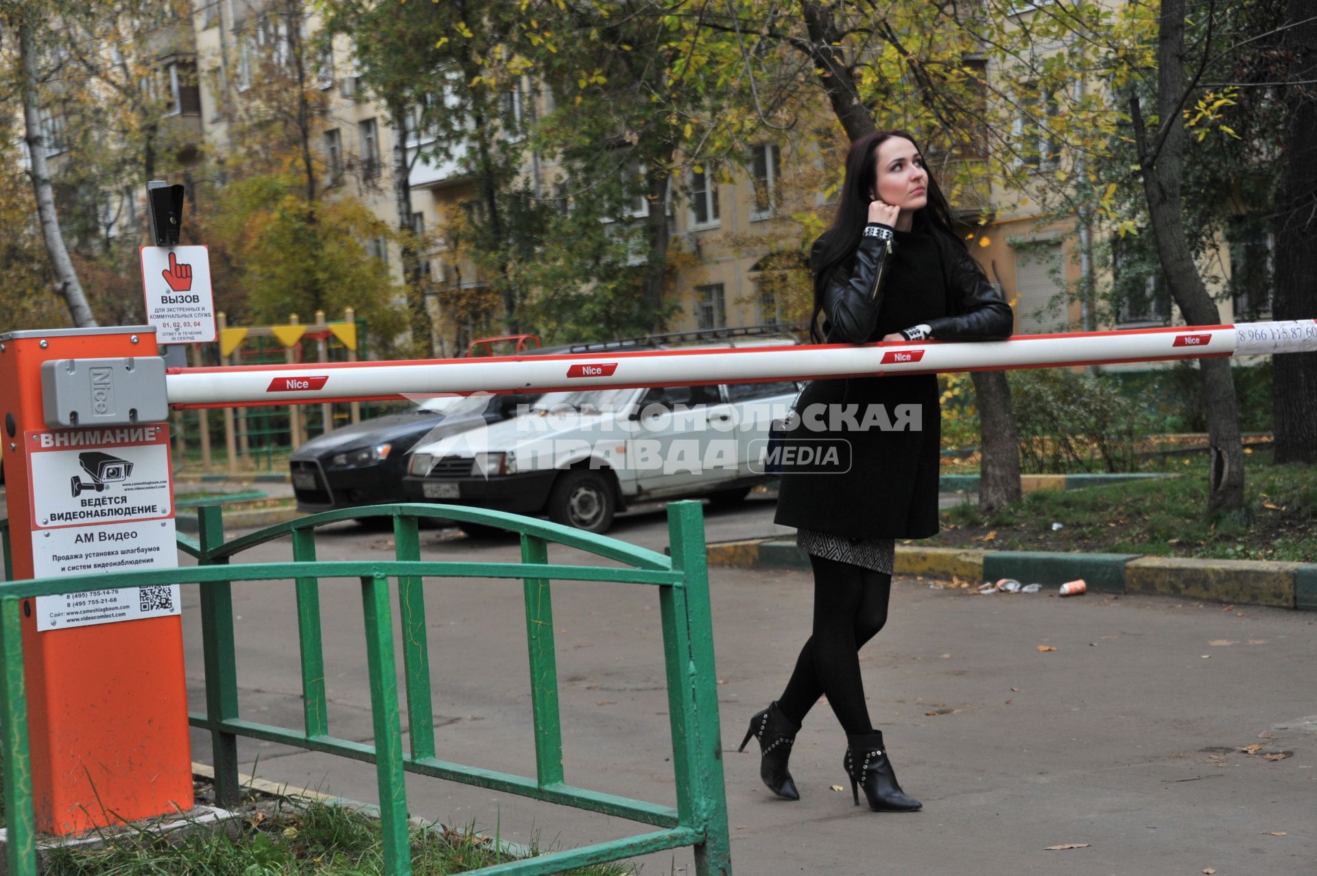 Москва.   Девушка у шлагбаума  во дворе жилого дома.