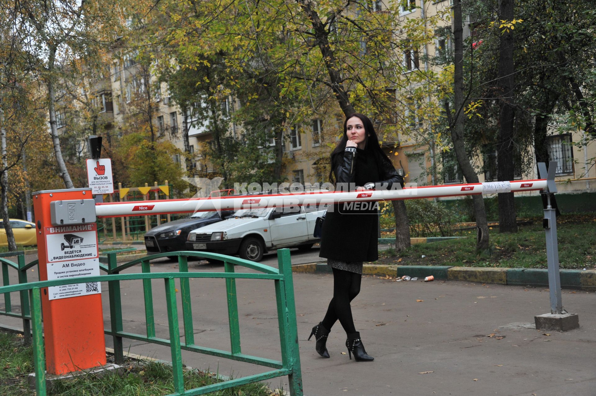 Москва.   Девушка у шлагбаума  во дворе жилого дома.