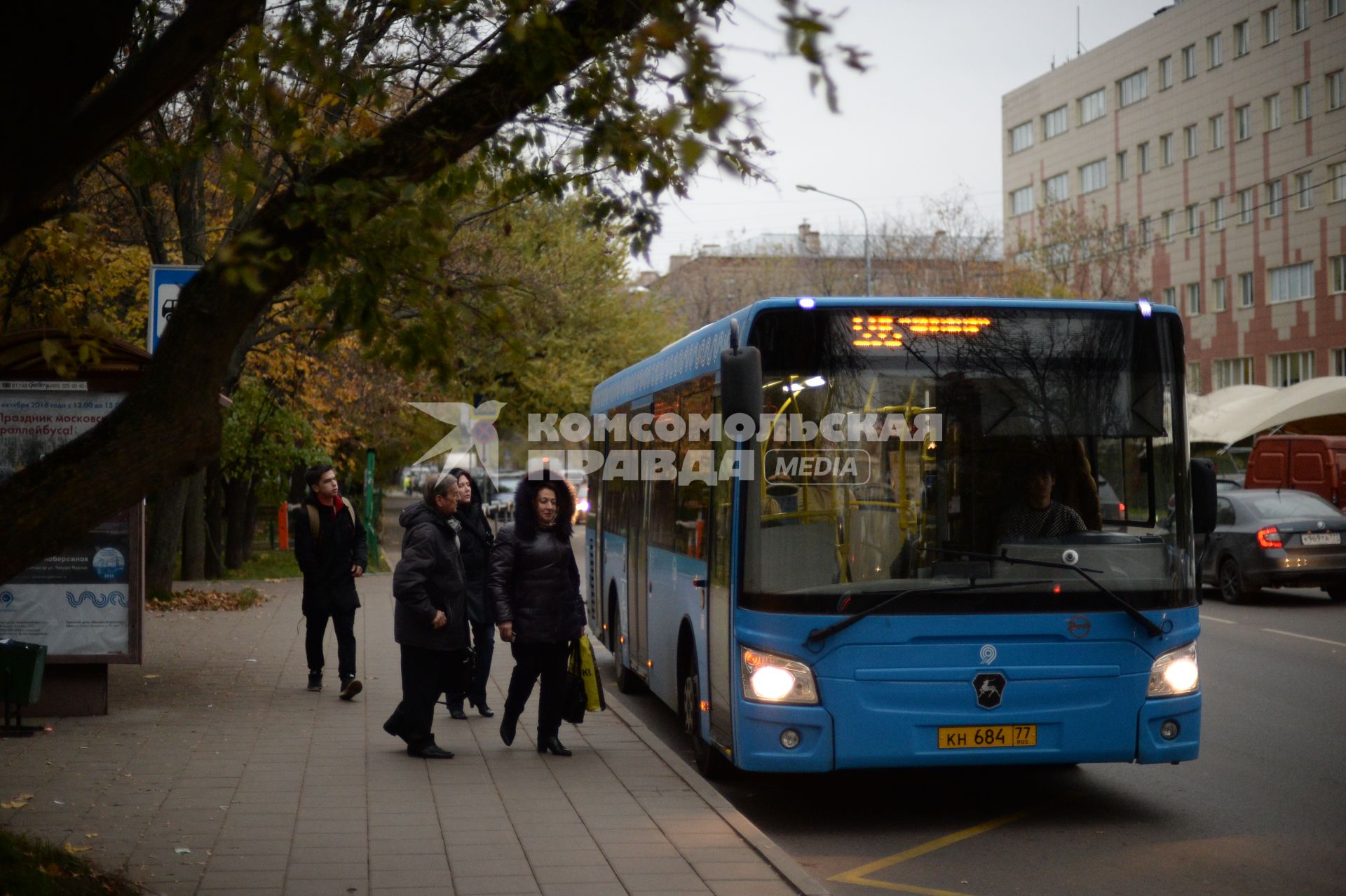 Москва. Пассажиры садятся в автобус на остановке общественного транспорта`Старый Петровско-Разумовский проезд`.