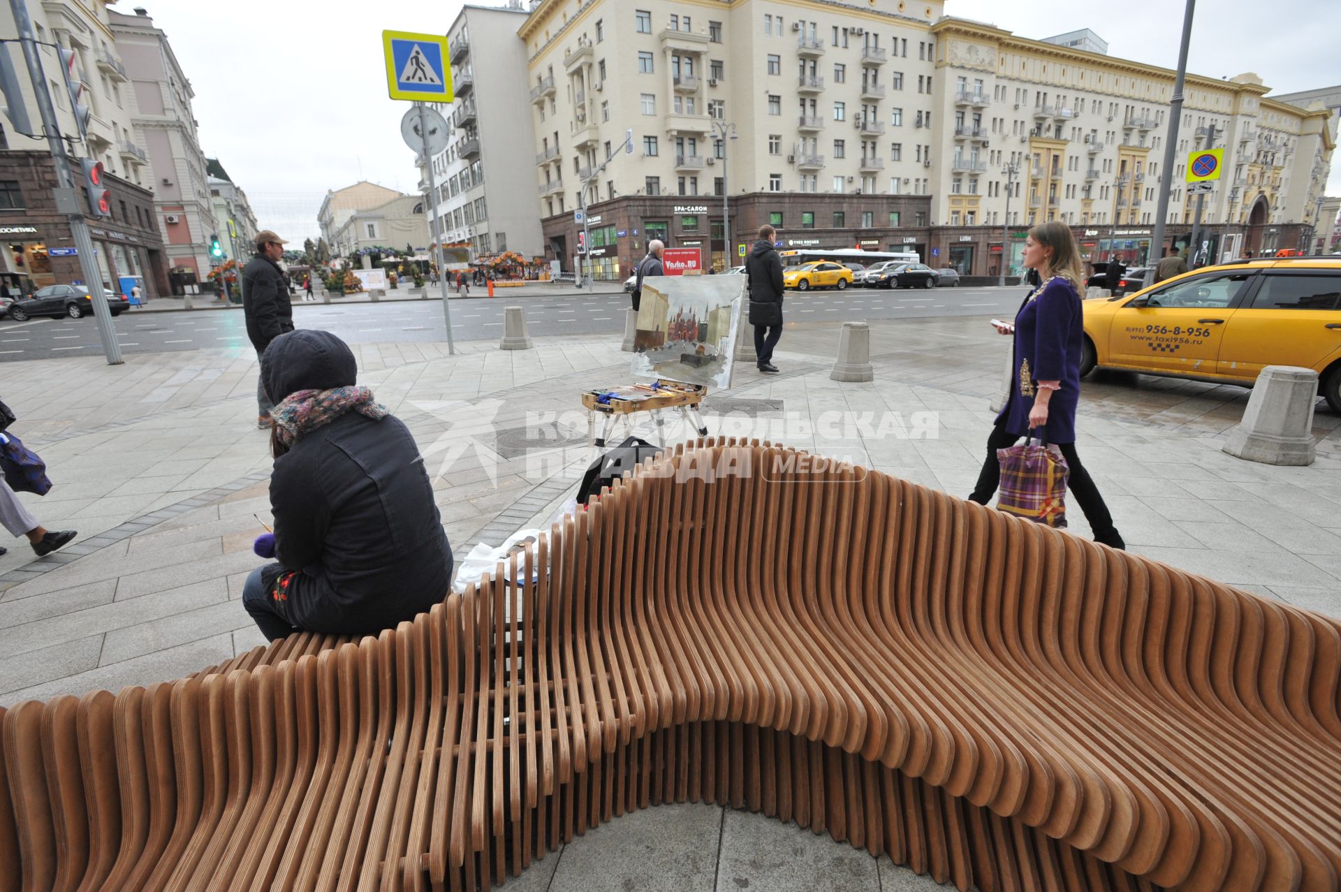 Москва.  Девушка отдыхает на скамейке на Тверской улице после ее реконструкции.