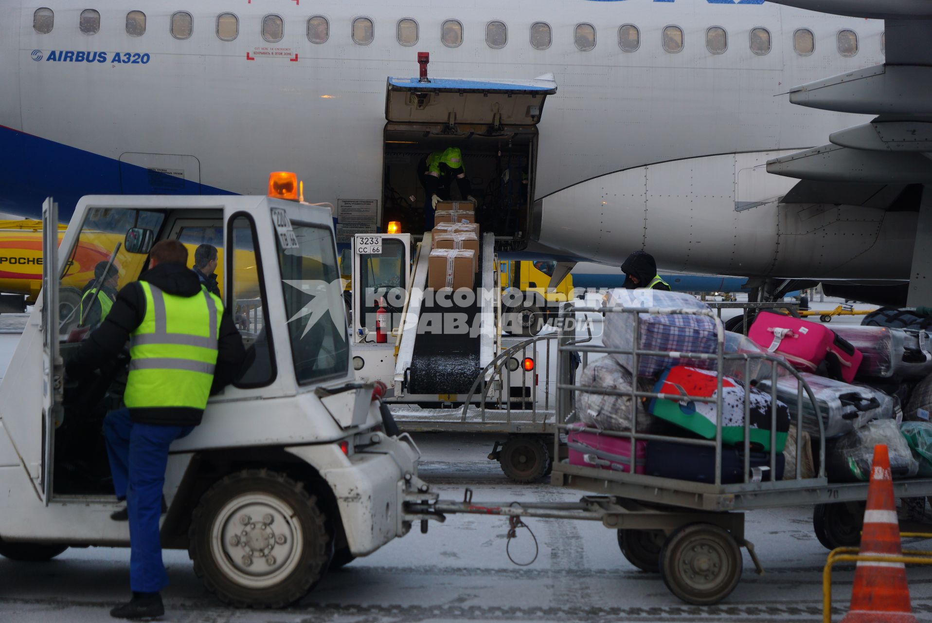 Екатеринбург. Международный аэропорт \'Кольцово\'. Сотрудники аэропорта грузят багад в самолет, перед его вылетом